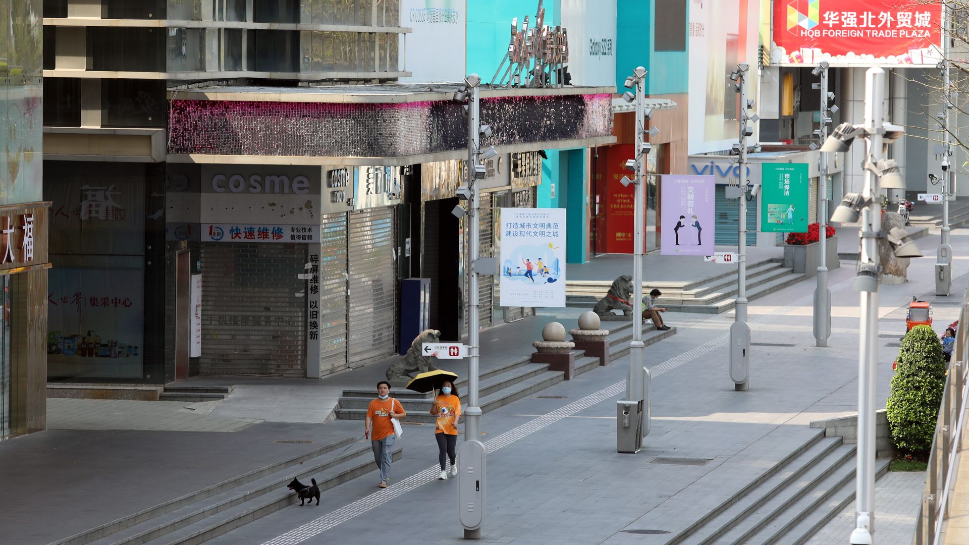 Two pedestrians walk down a deserted city street