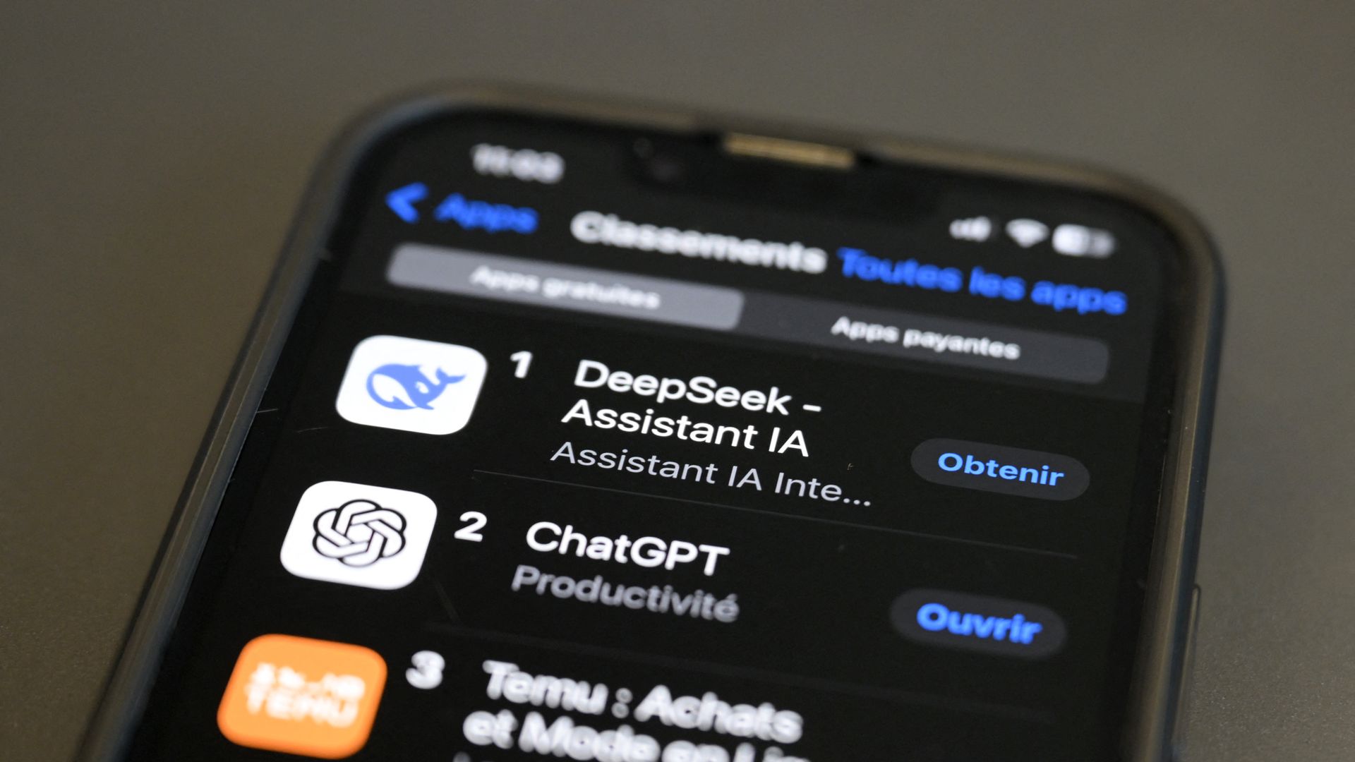 The DeepSeek app logo displayed in an app store on a mobile phone above ChatGPT and Temu.