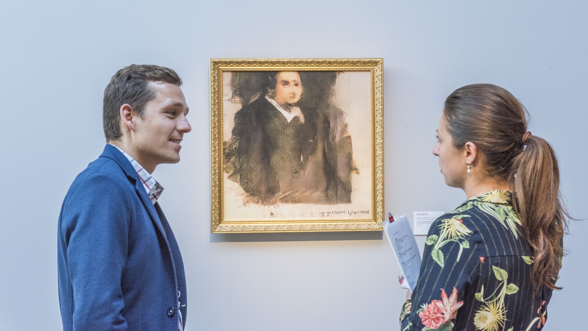 A man and a woman speak to one another in front of an AI-generated portrait in a gallery.