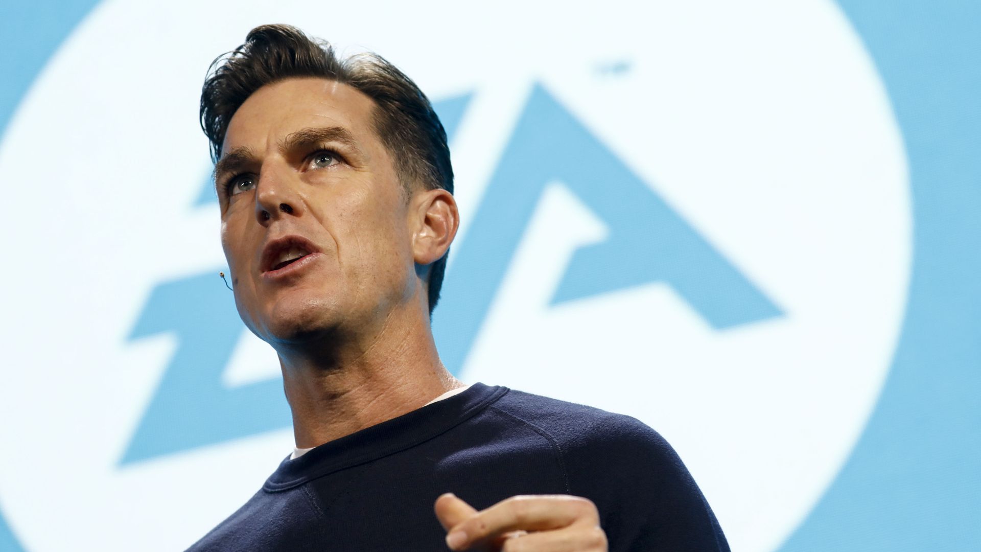 Photo of a man standing in front of an EA logo