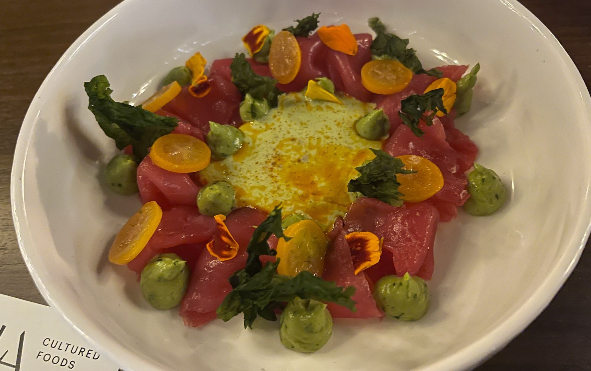 Whit bowl with sashimi looking cuts and avocado mouse.