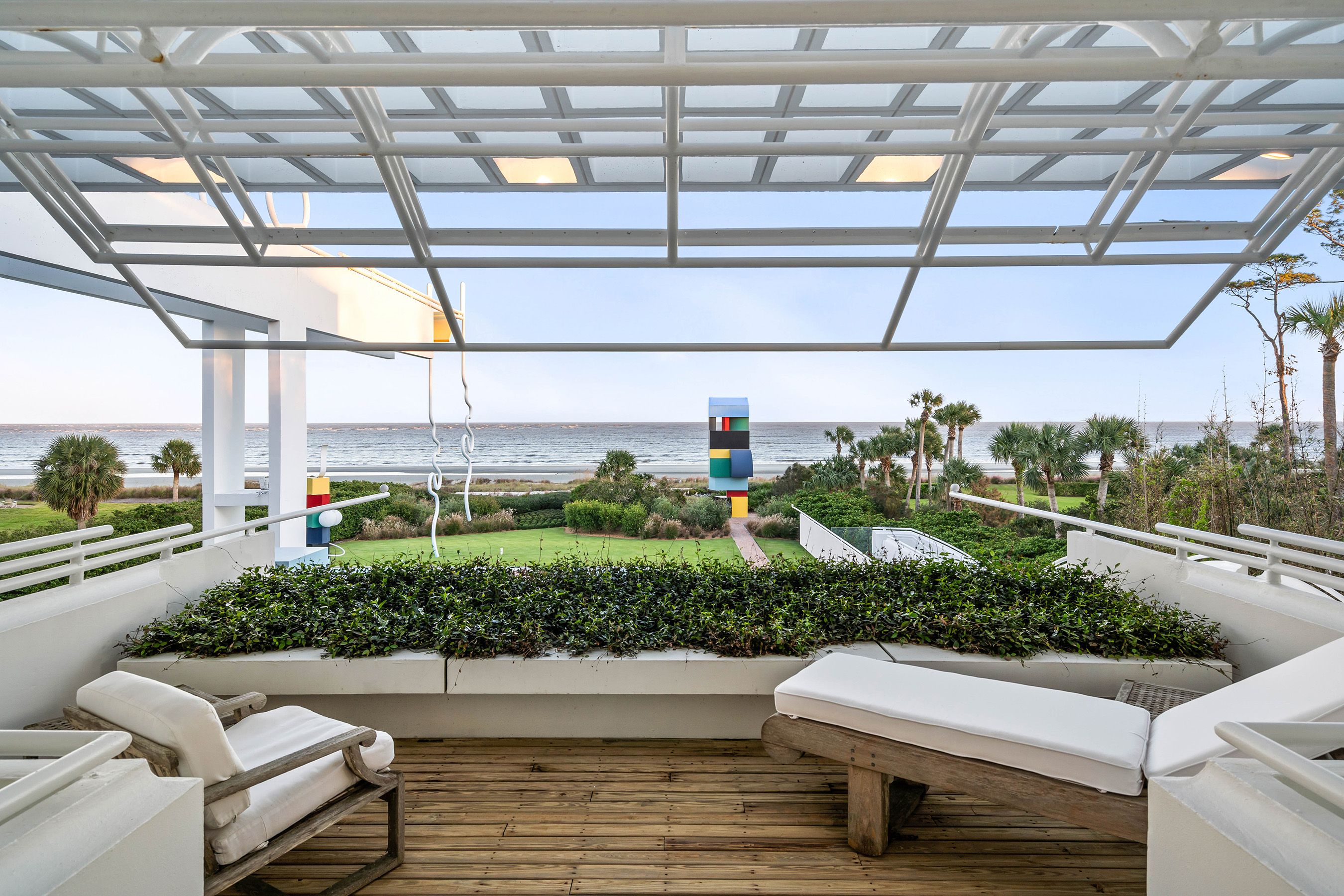 A photo of lounge chairs on a balcony looking out on to the ocean