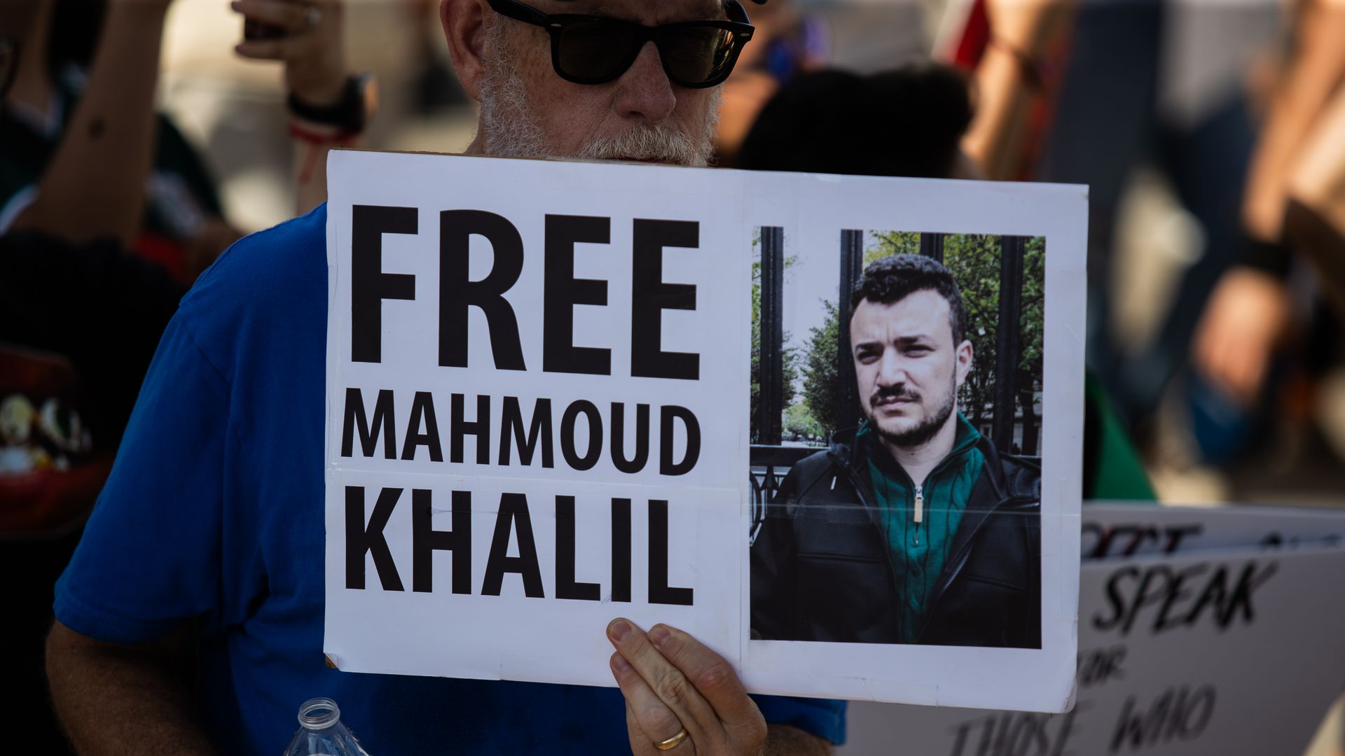 Protesters gather at Ervan Chew Park in Houston, Texas, on June 8, 2025, for a demonstration against Trump immigration policies and mass deportations. A protester holds a sign that reads, ''Free Mahmoud Khalil.''