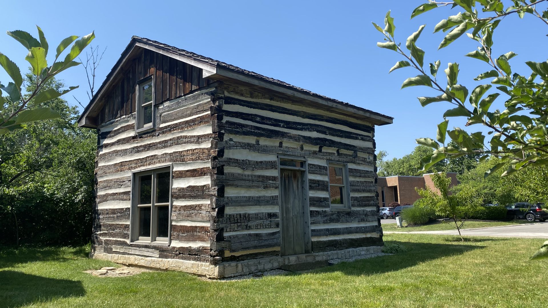 A log cabin with tree branches in the foreground