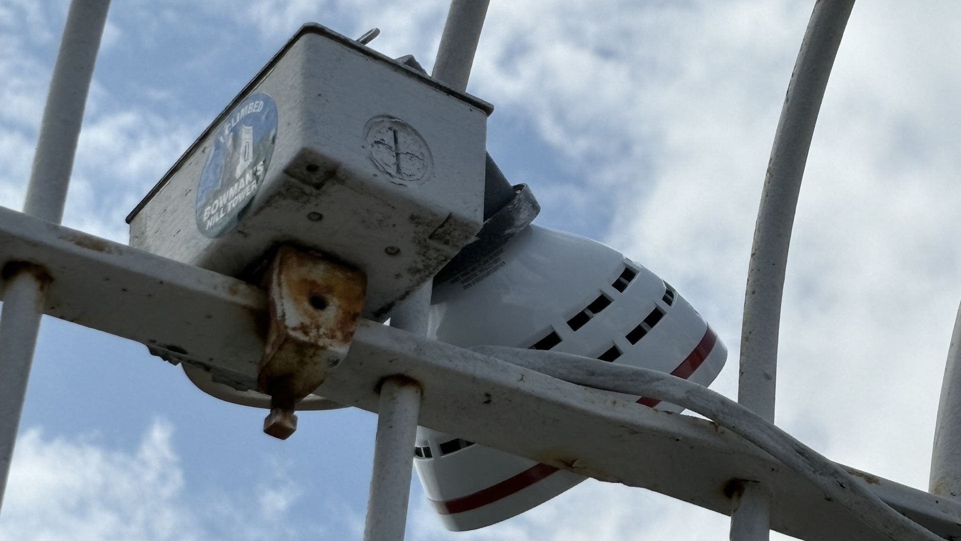 A "I climbed Bowman's Hill Tower" sticker attached to fencing at the top of the structure. 