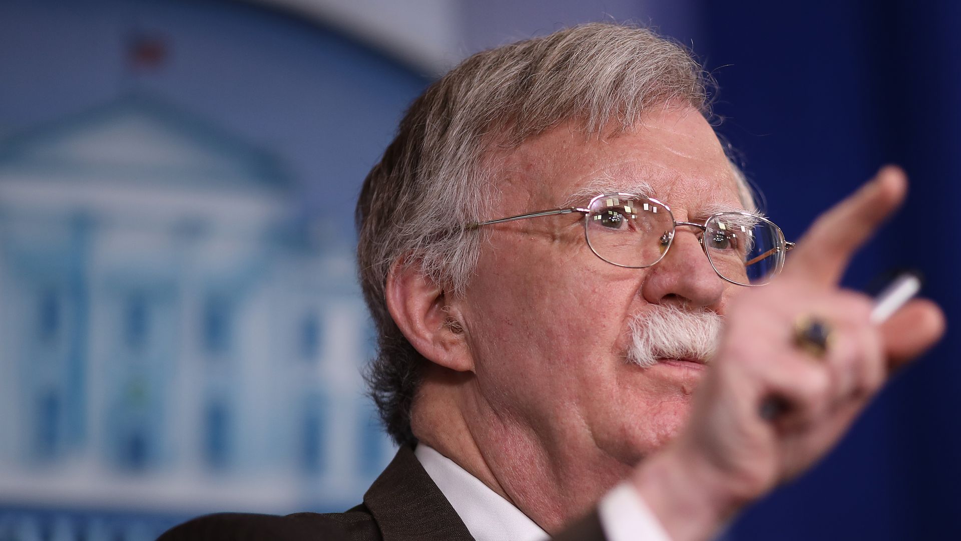 In this image, John Bolton waves a finger while speaking at a White house press briefing. 