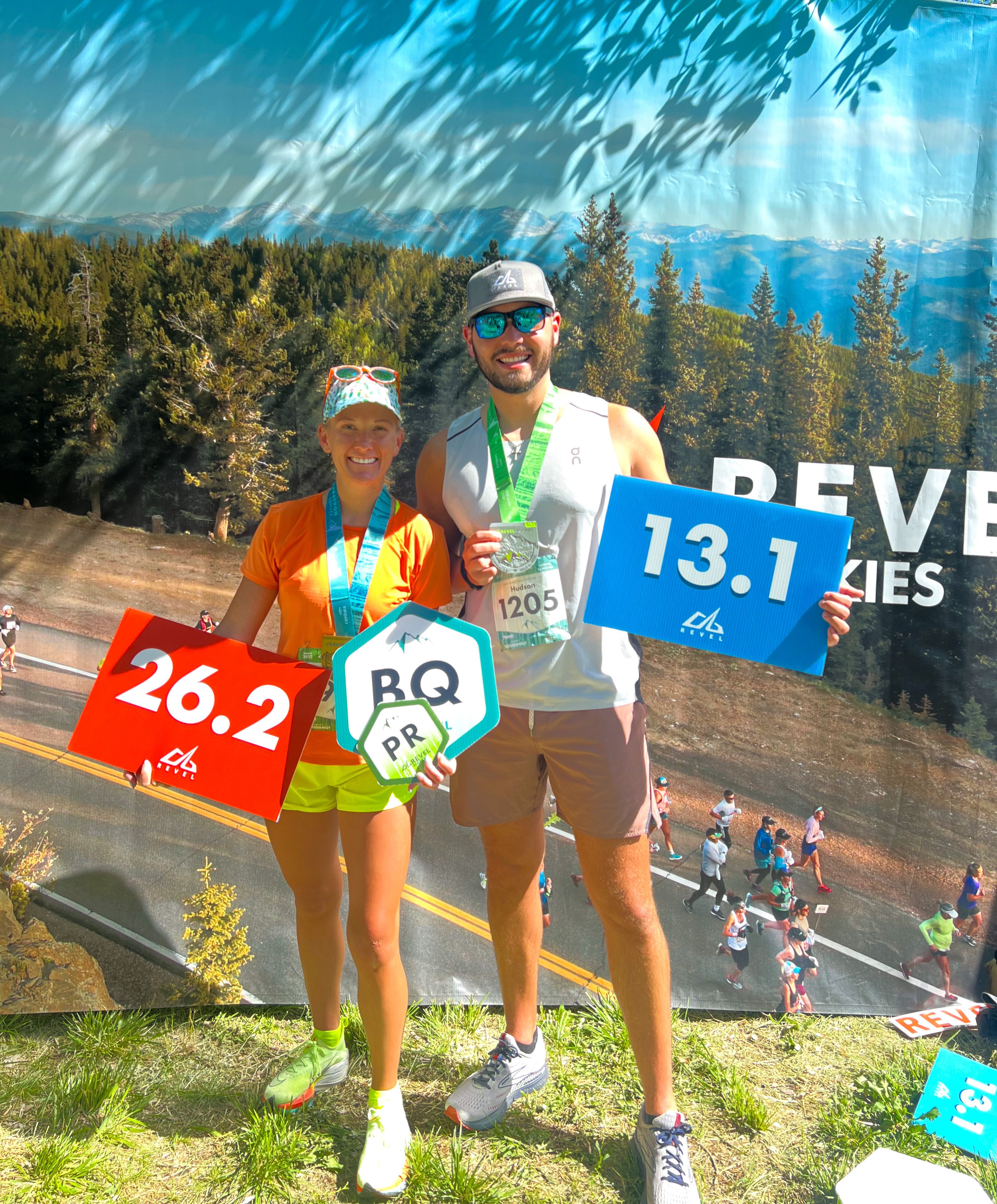Kayleigh Hudson (left) holding a "BQ" sign next to her husband Matthew Bennett. 