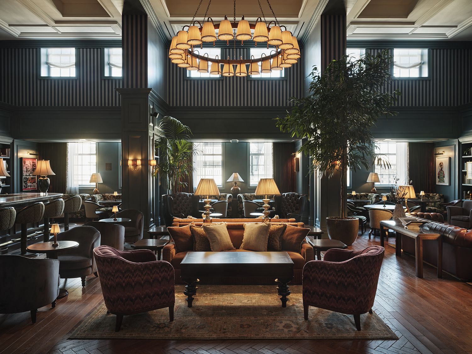 A picture of a grand room with couches, a bar on the side, and art on the walls