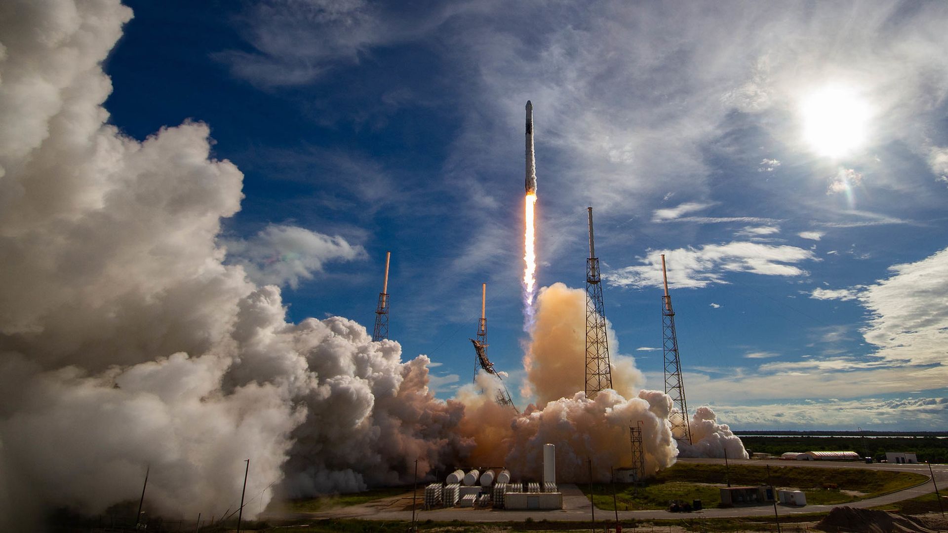 A SpaceX rocket launching in Florida on a blue day
