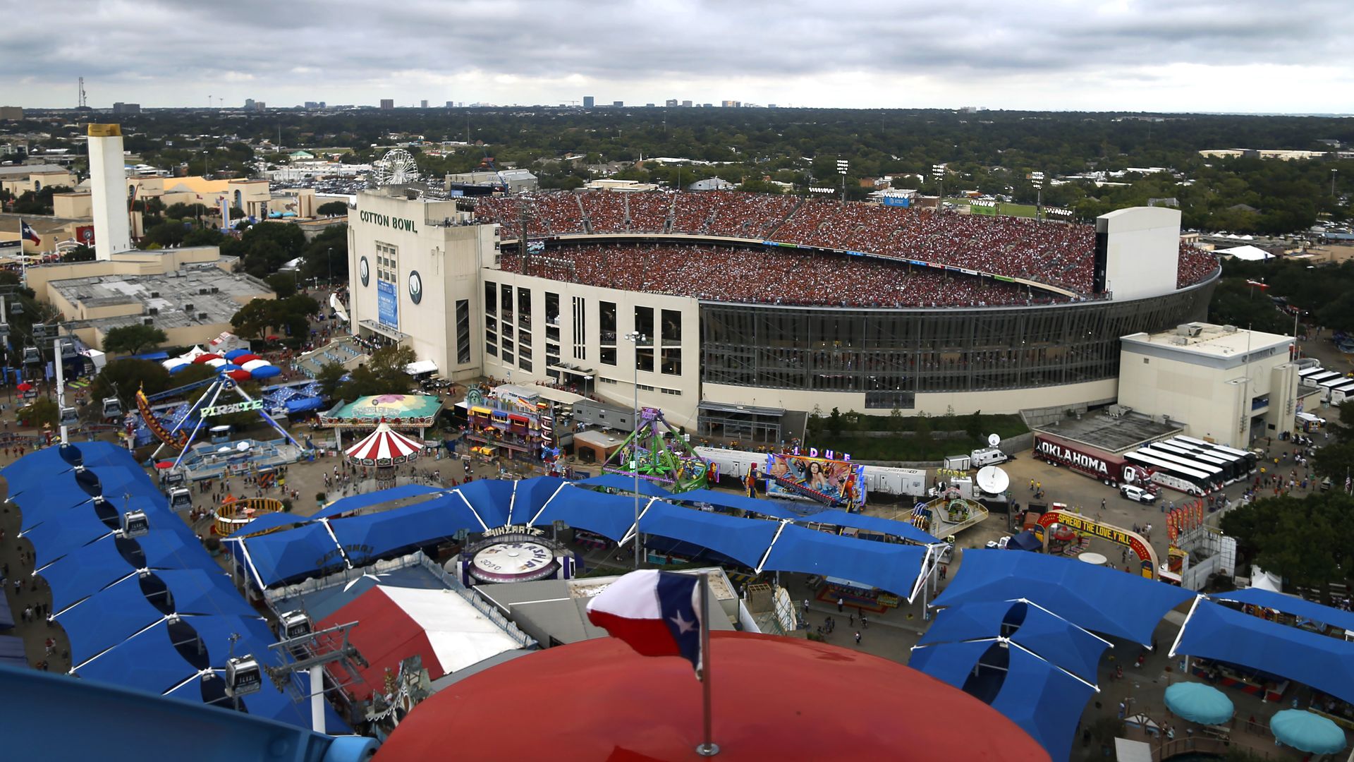 An aerial view of a football stadium next to fair rides