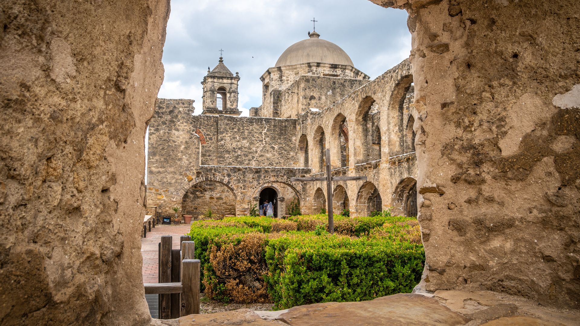 Mission San Jose seen through an opening in the stone walls.