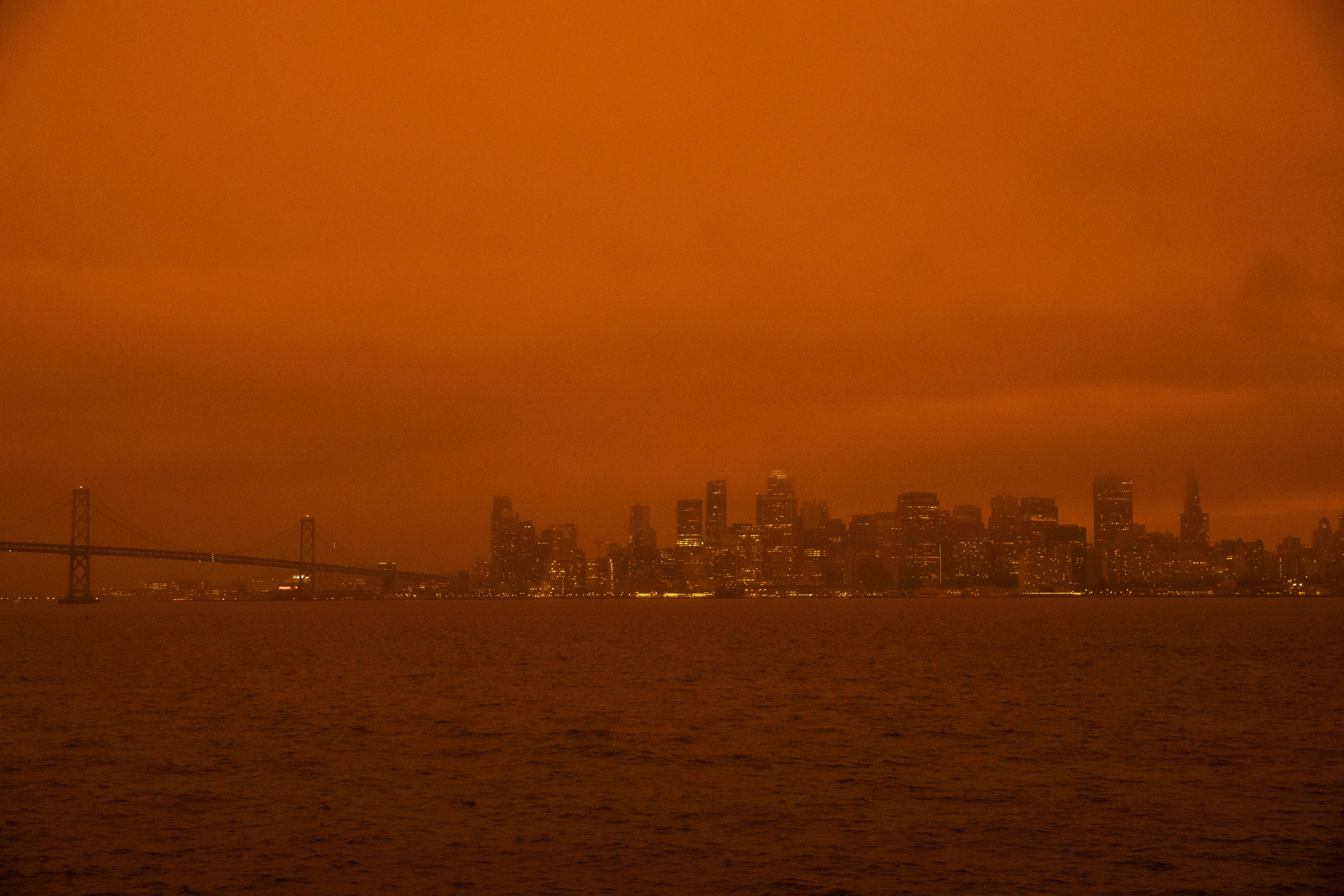 Long-distance view of the San Francisco skyline through a haze of red smoke