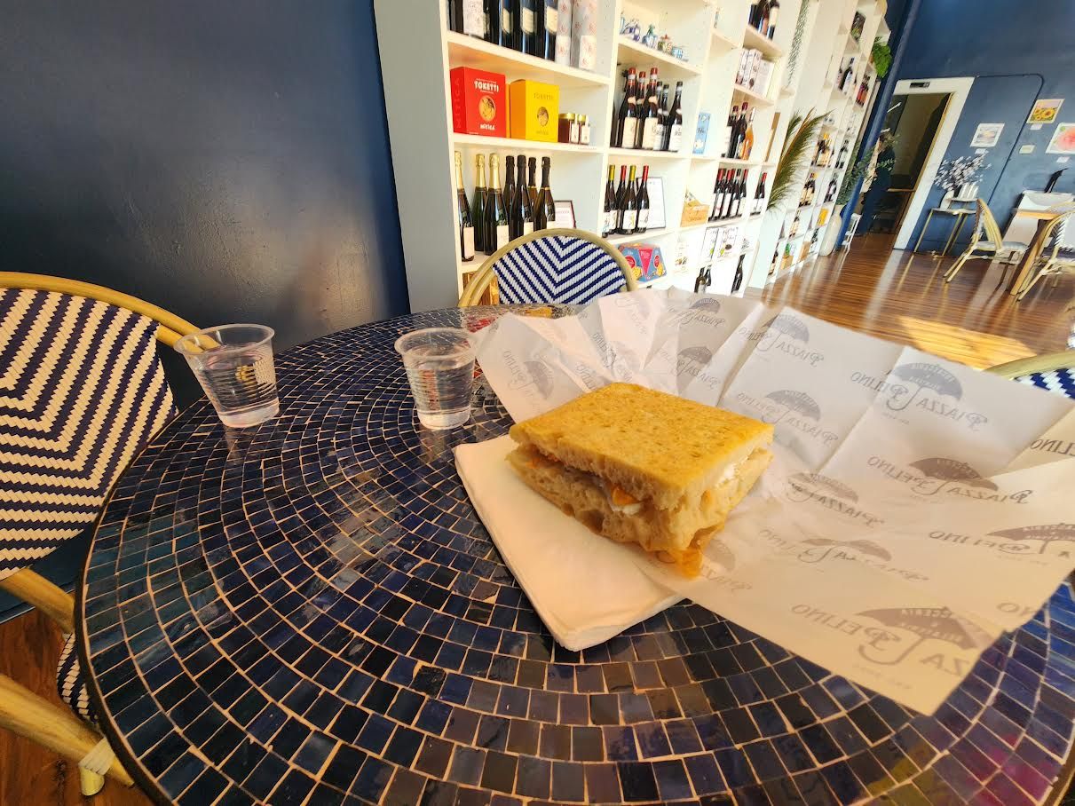 A sandwich made of foccacia bread and fresh ingredients on a table.