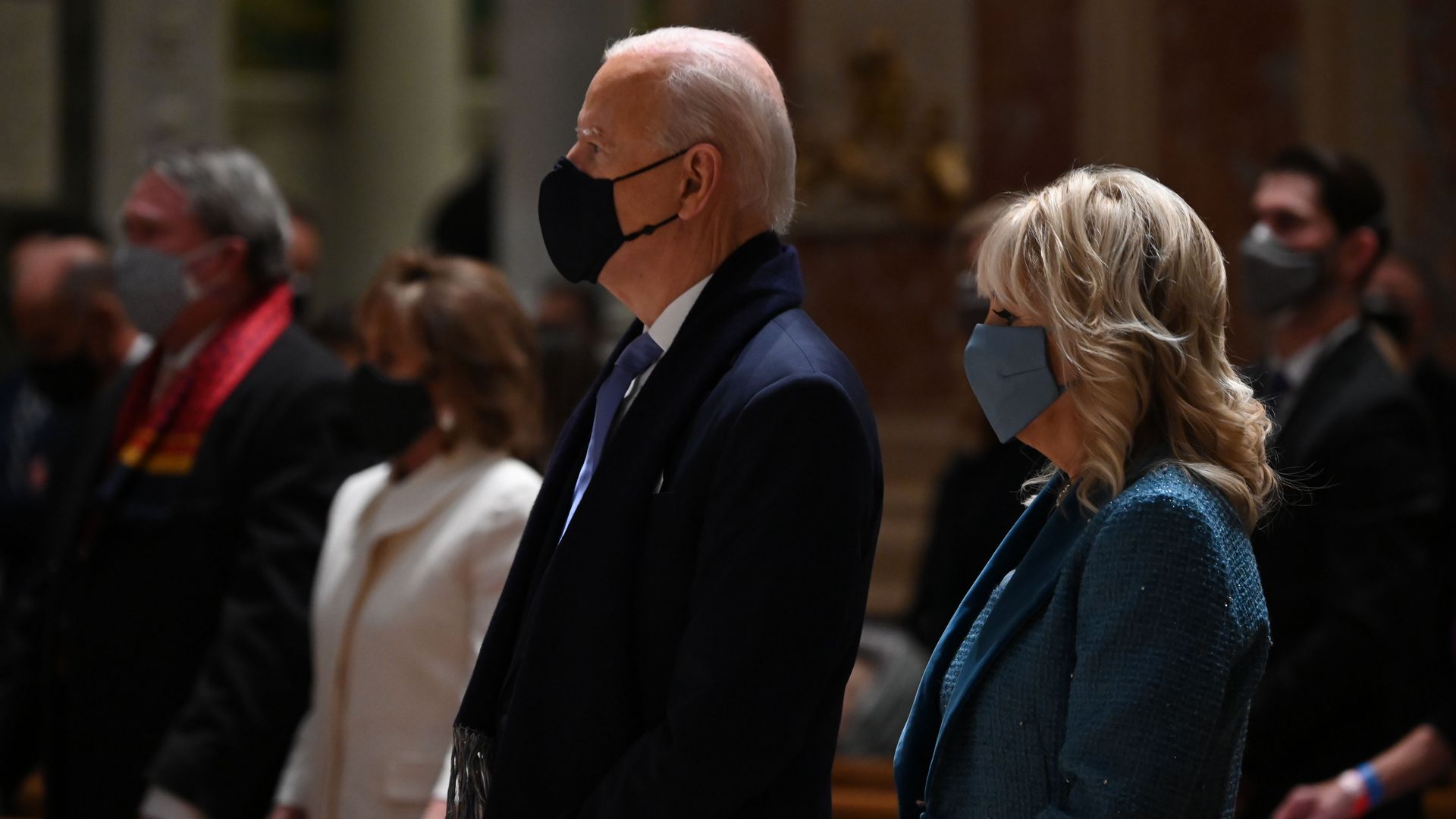 Joe and Jill Biden stand in a church pew 