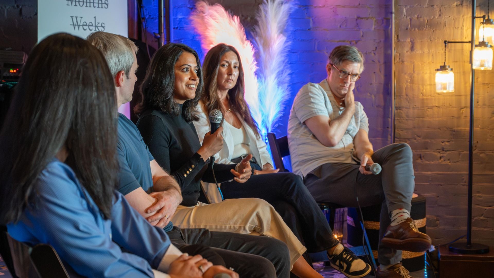 One person in a panel discussion of five professionals speaks as the others listen. 