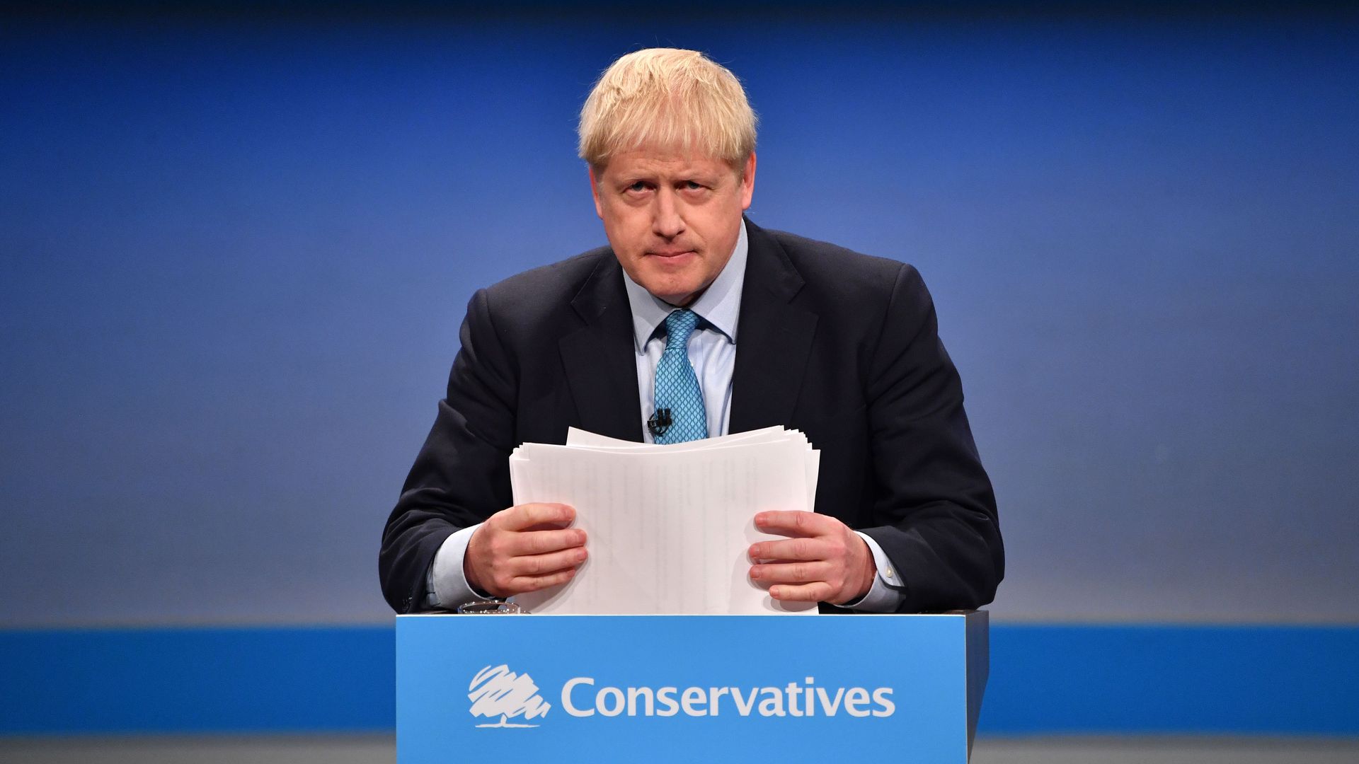 Britain's Prime Minister Boris Johnson shuffles his papers as he delivers his keynote speech