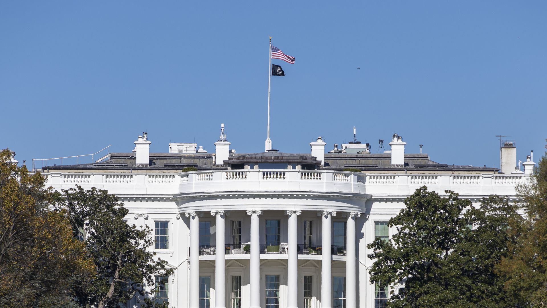 The White House in Washington, D.C., against a blue sky.