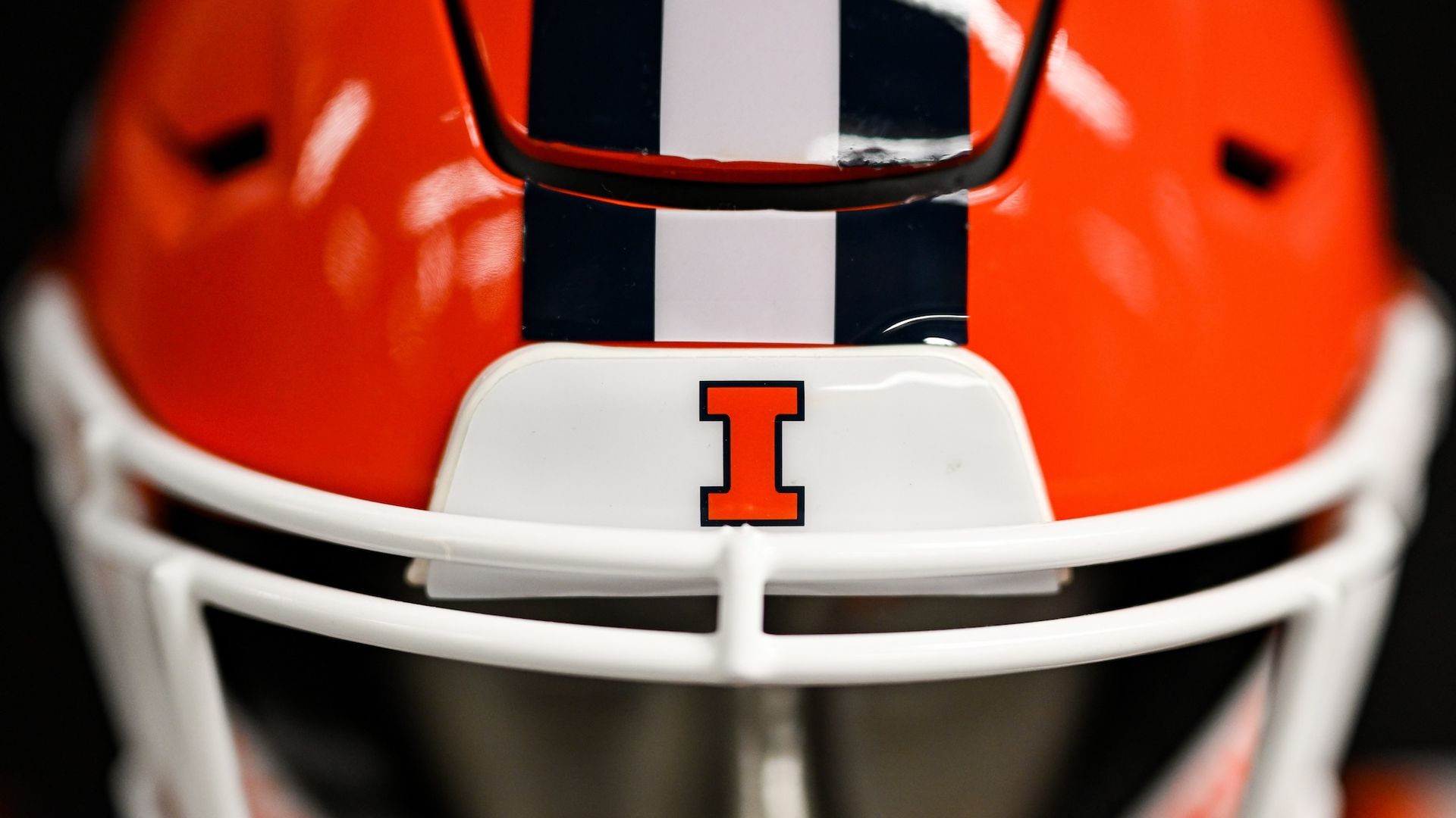 Orange, white and blue football helmet of University of Illinois I on it.