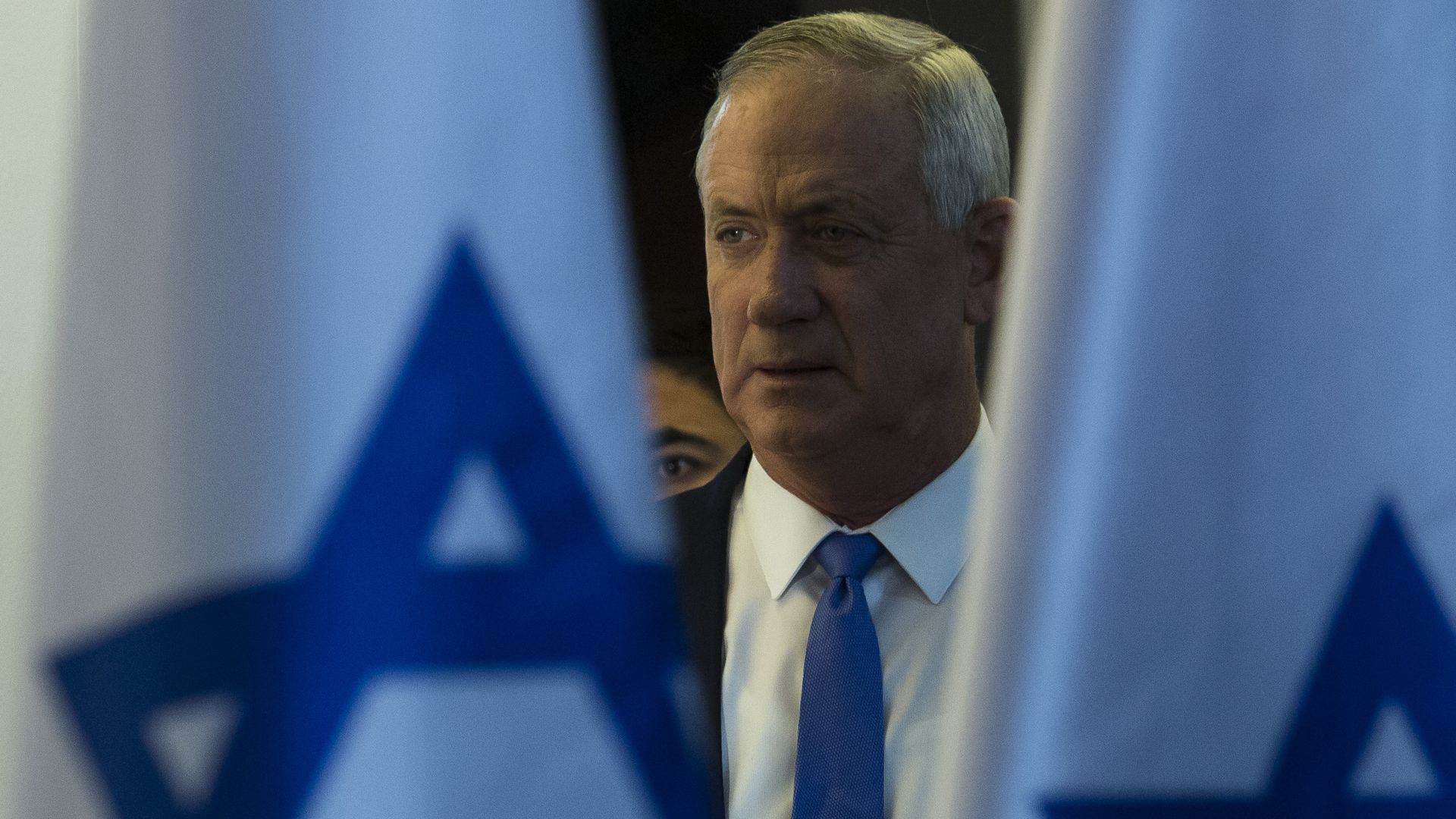 Benny Gatz stands between two Israeli flags.