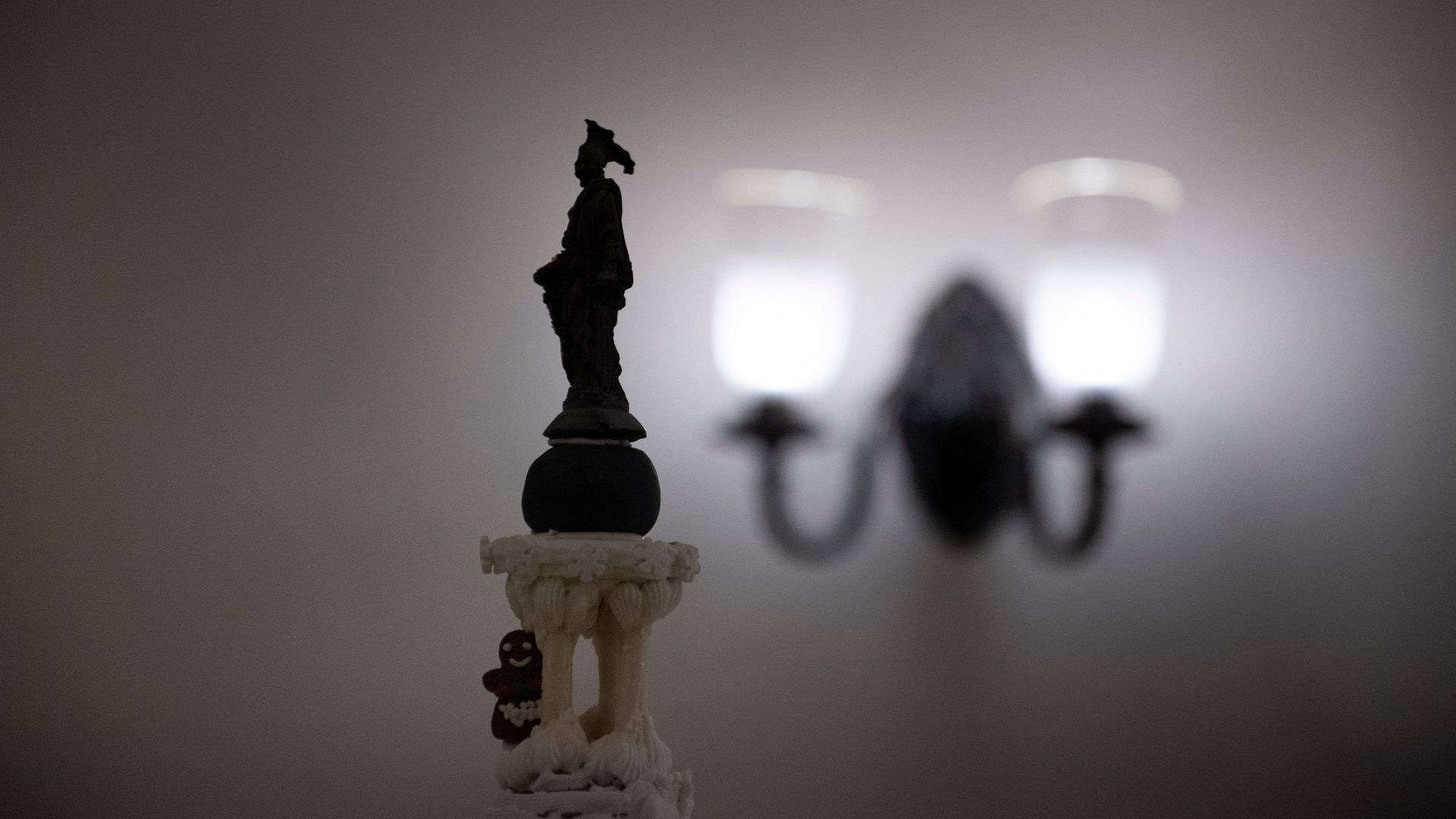 The Statue of Freedom is seen in silhouette atop a gingerbread replica of the U.S. Capitol.