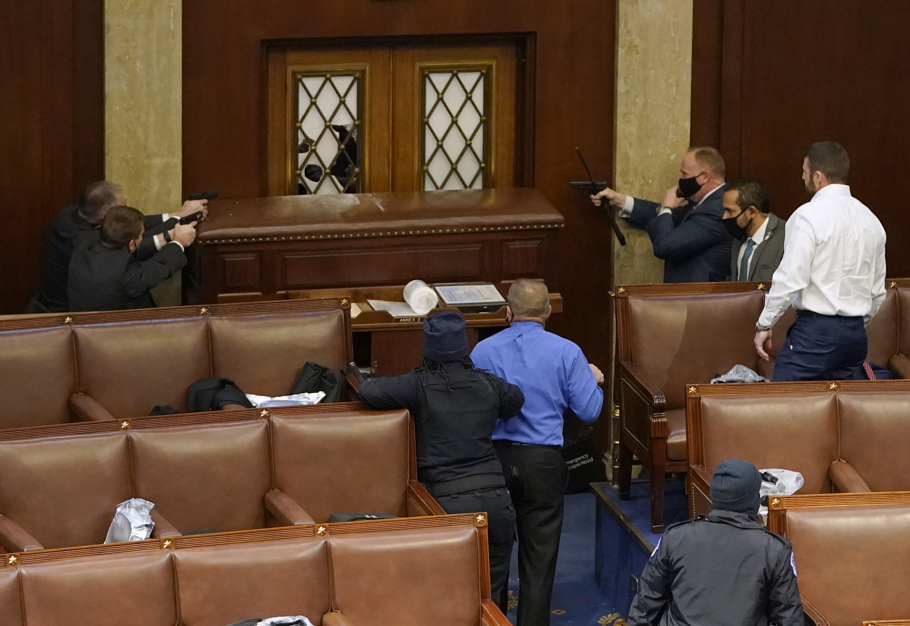 Capitol Police Officers are seen holding back protesters from breaking through the doors of the House Chamber on Jan. 6.
