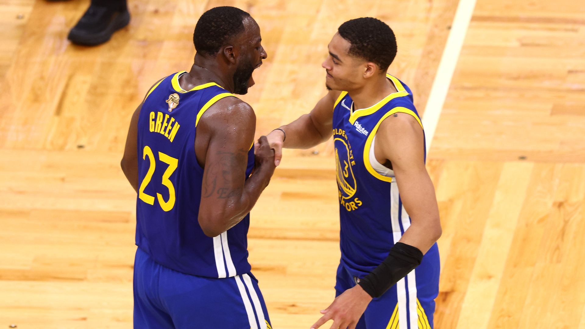 Jordan Poole #3 and Draymond Green #23 of the Golden State Warriors celebrate against the Boston Celtics.