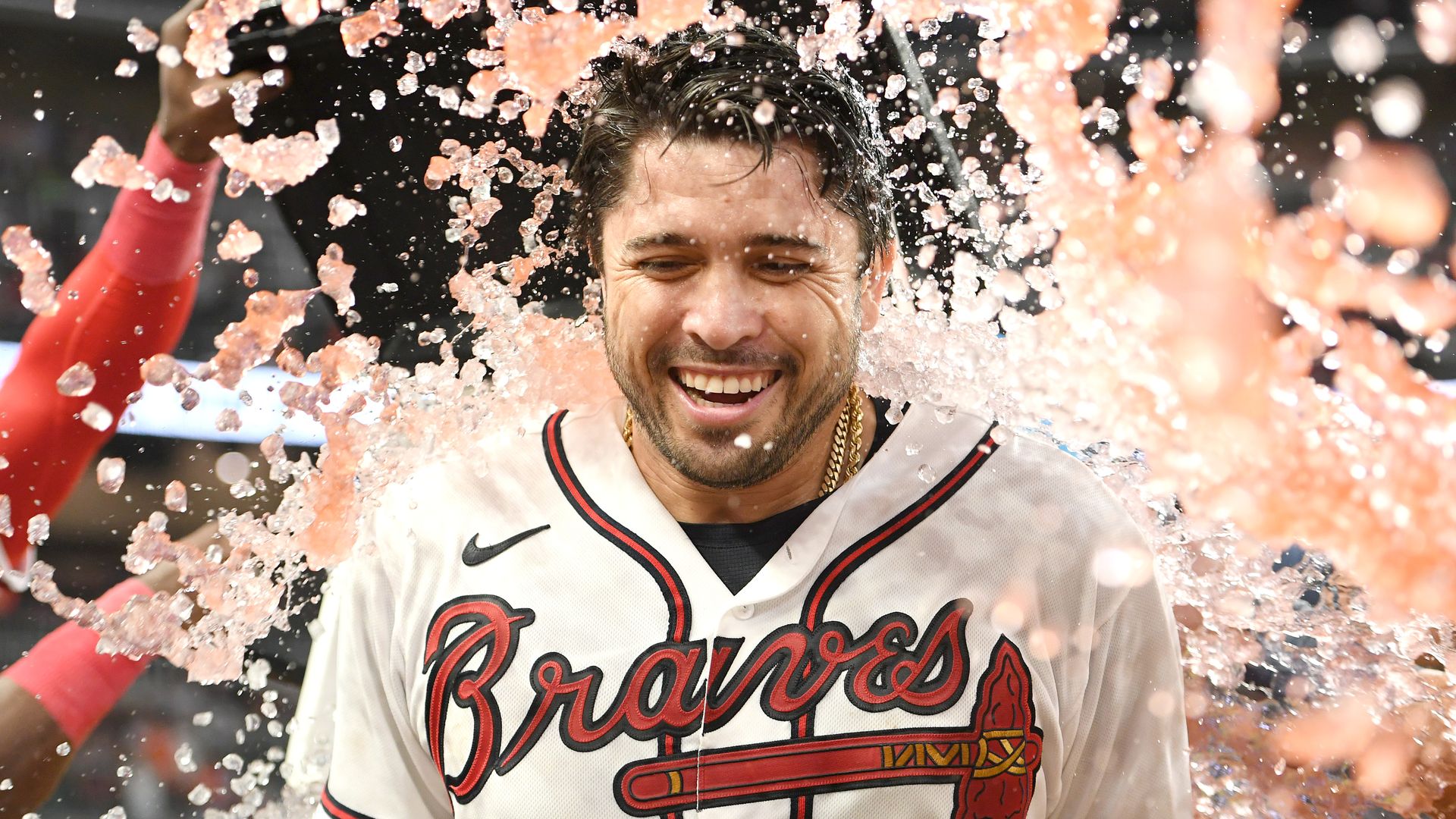 baseball player in a Braves uniform getting showered by pink liquid that's probably gatorade
