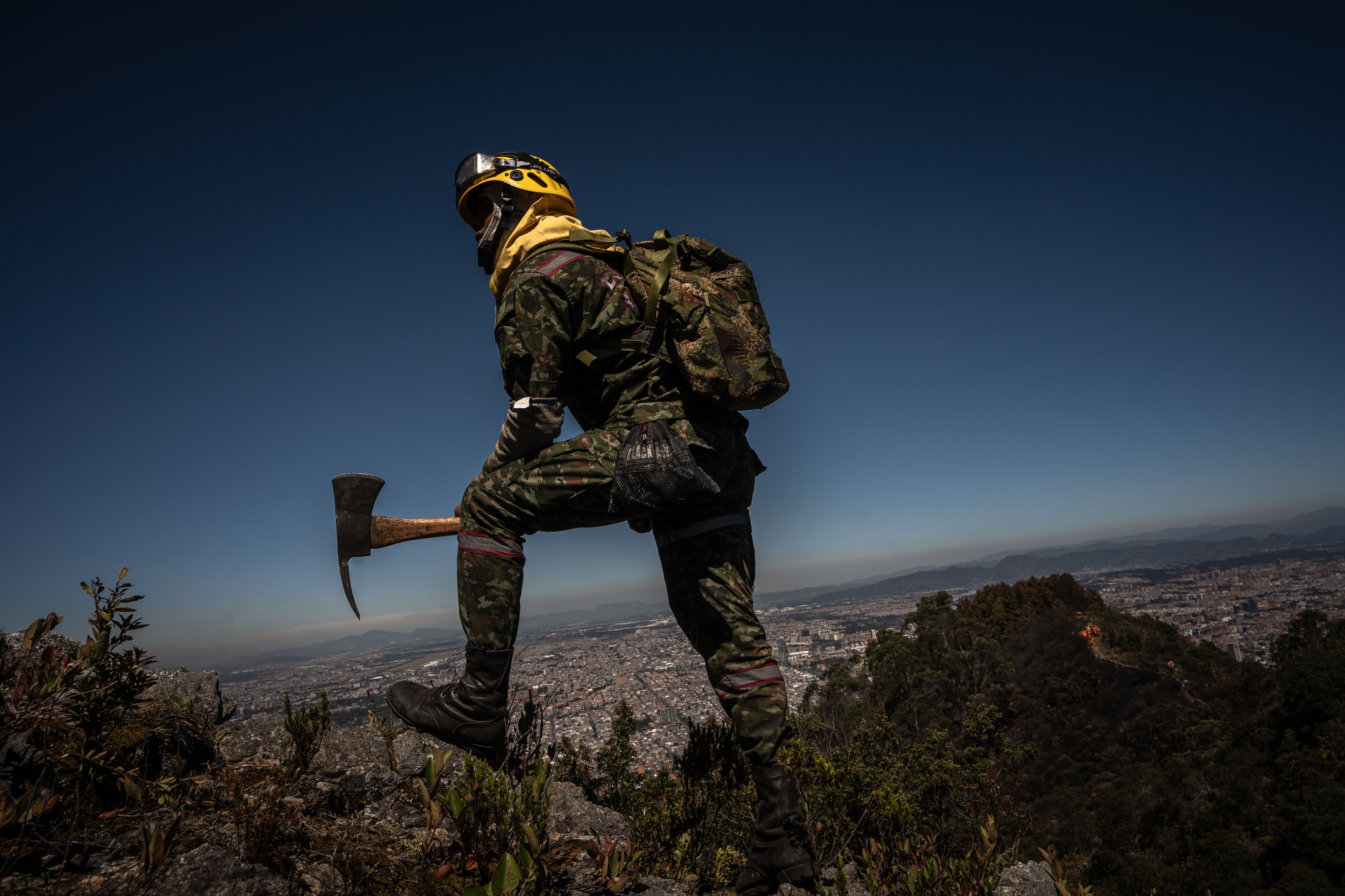 A close up photograph of a rescuer holding an axe in the mountains near Bogota. 