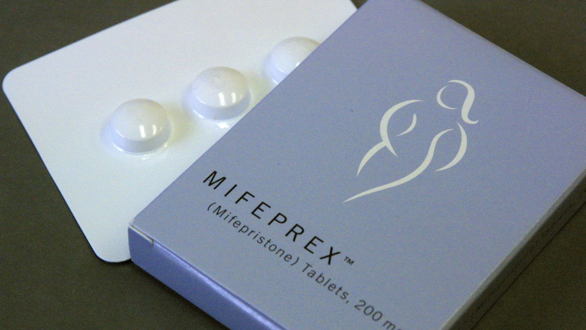Photo of Mifeprex pills laid out next to the brand's box