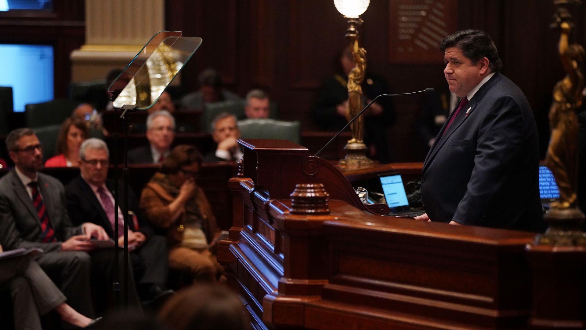 A photo of a man at a podium giving a speech.