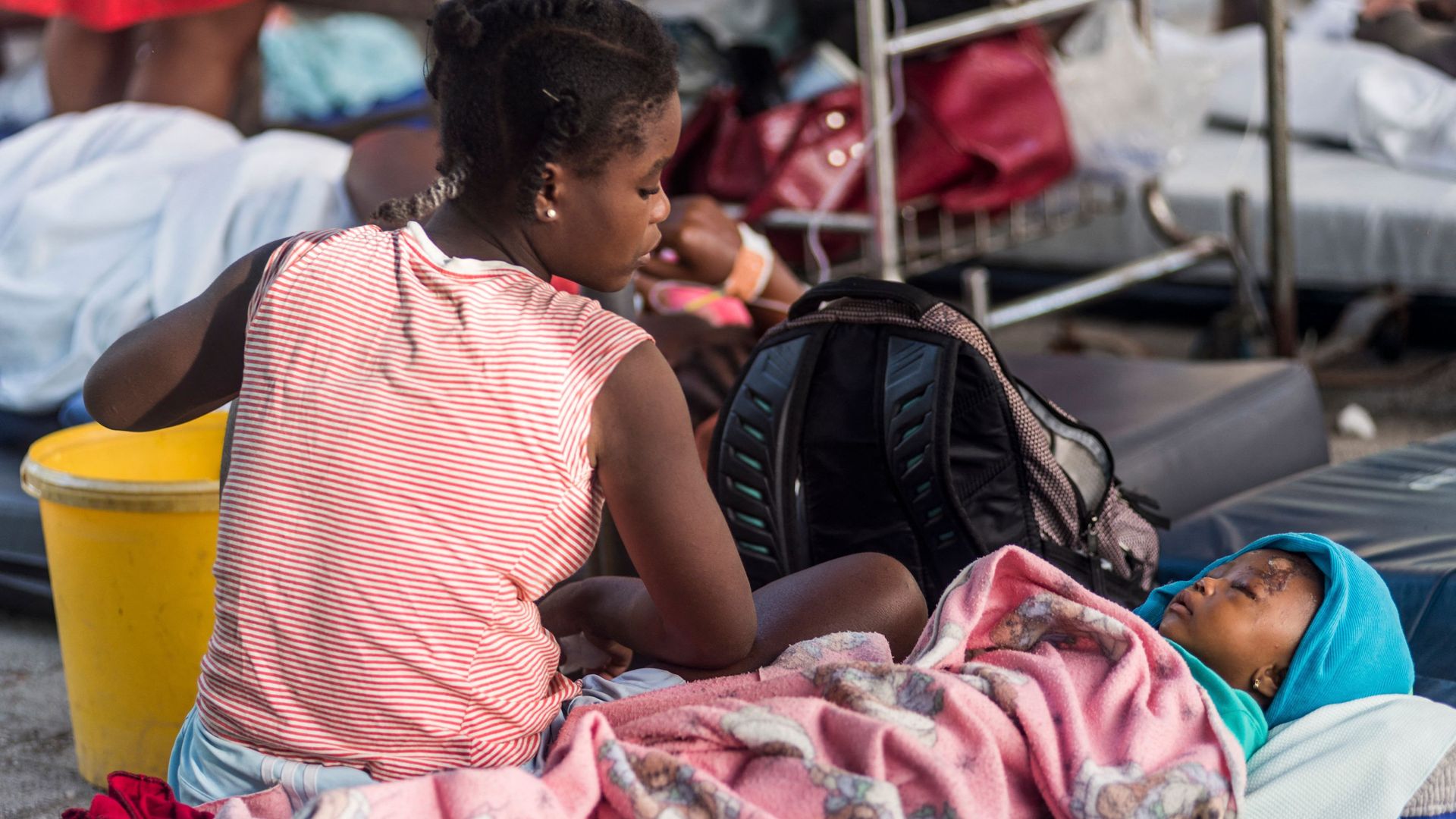 A young mother looks on at her daughter, injured as a result of the earthquake in Haiti.