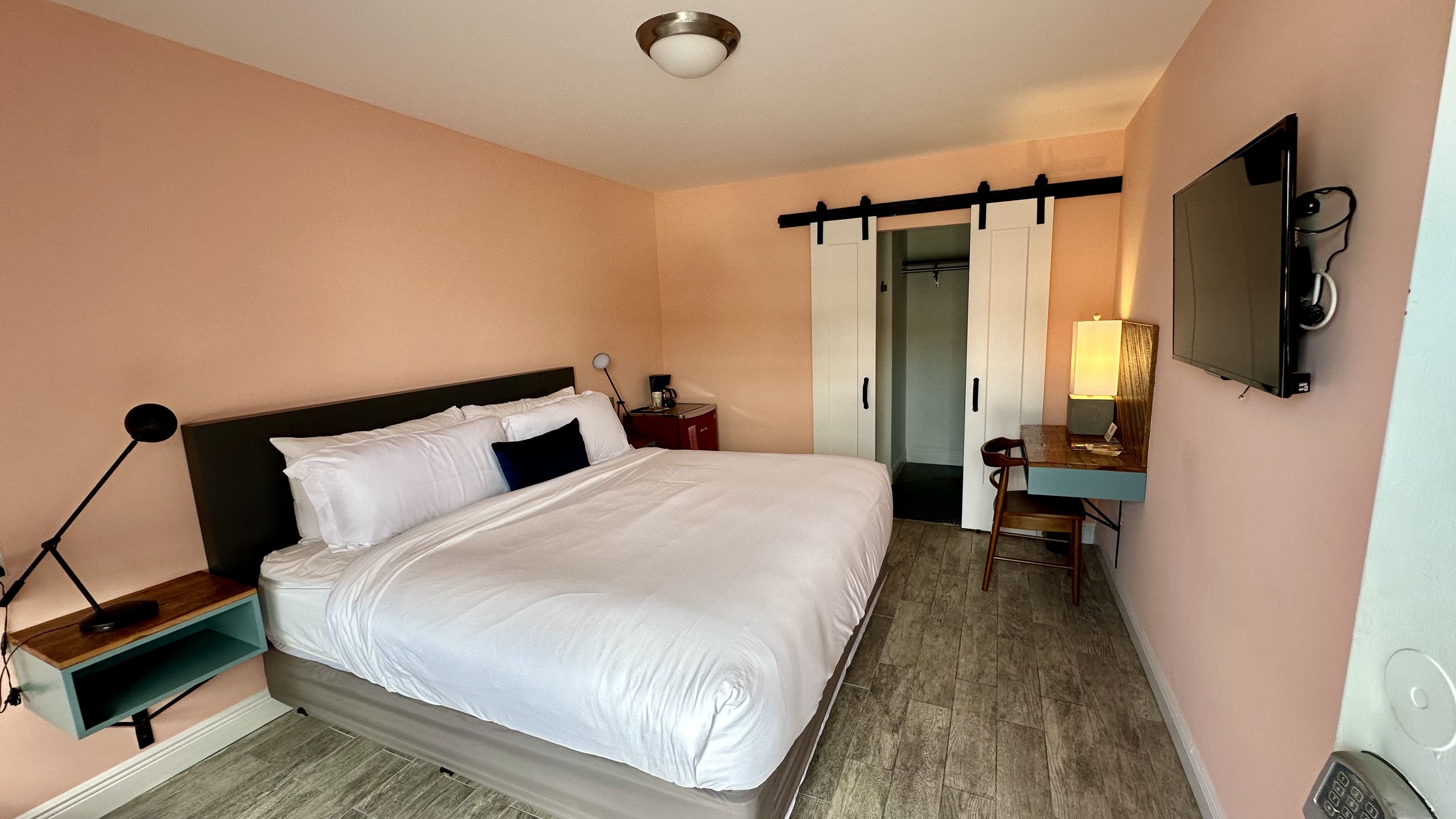 Photo shows a hotel room with a bed.