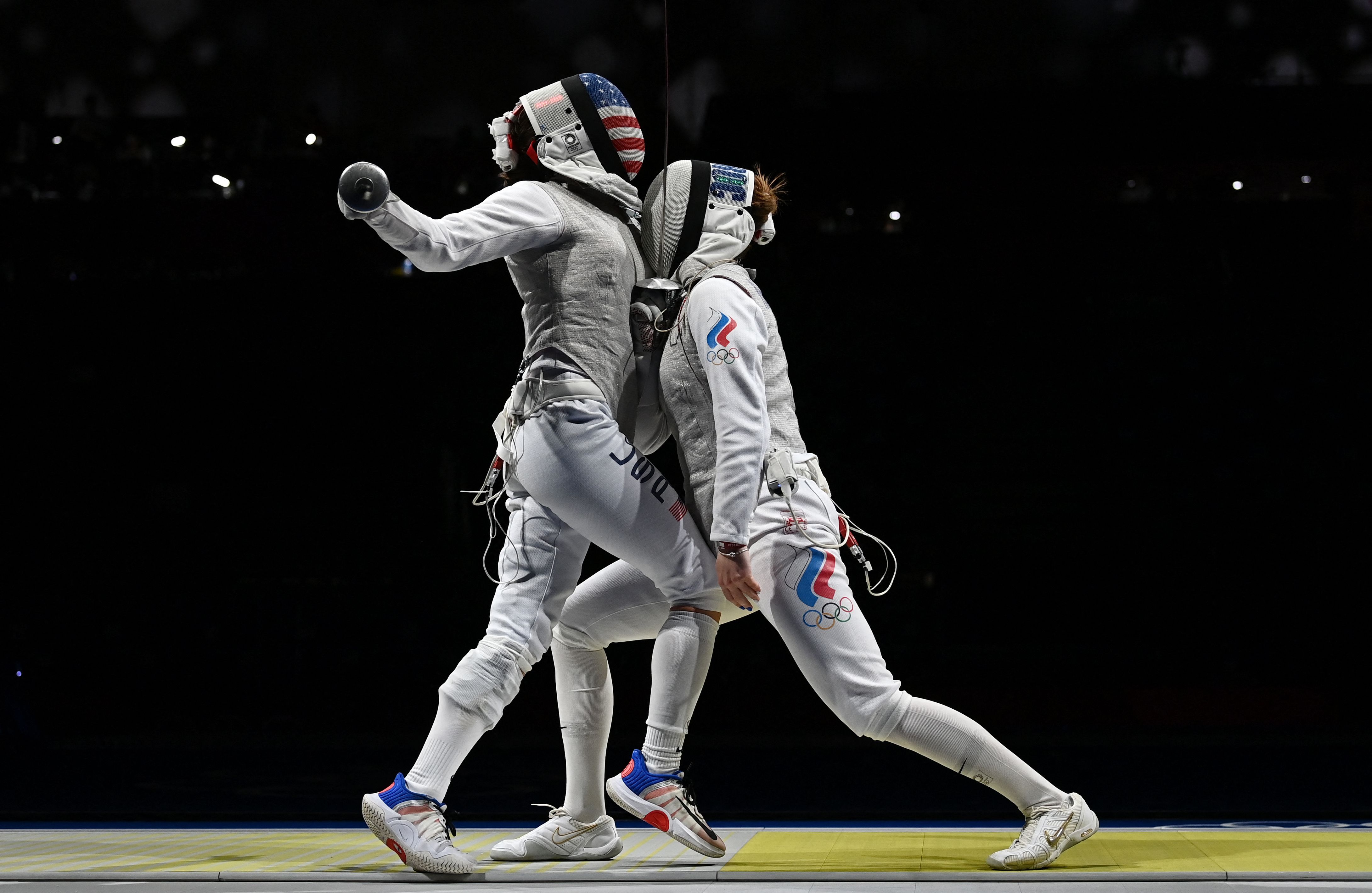 USA's Nicole Ross (L) compete against Russia's Marta Martyanova in the women's foil team semifinal bout during the Tokyo 2020 Olympic Games on July 29