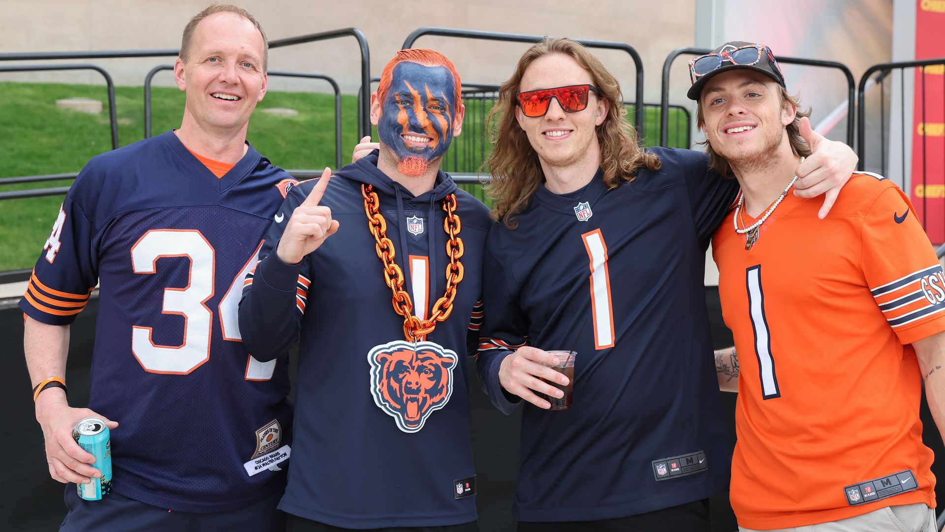 Photo of men wearing football jerseys posing for the camera.