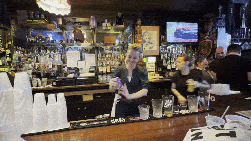 Image shows Mayor Helena Moreno serving a beer in a can at a bar.