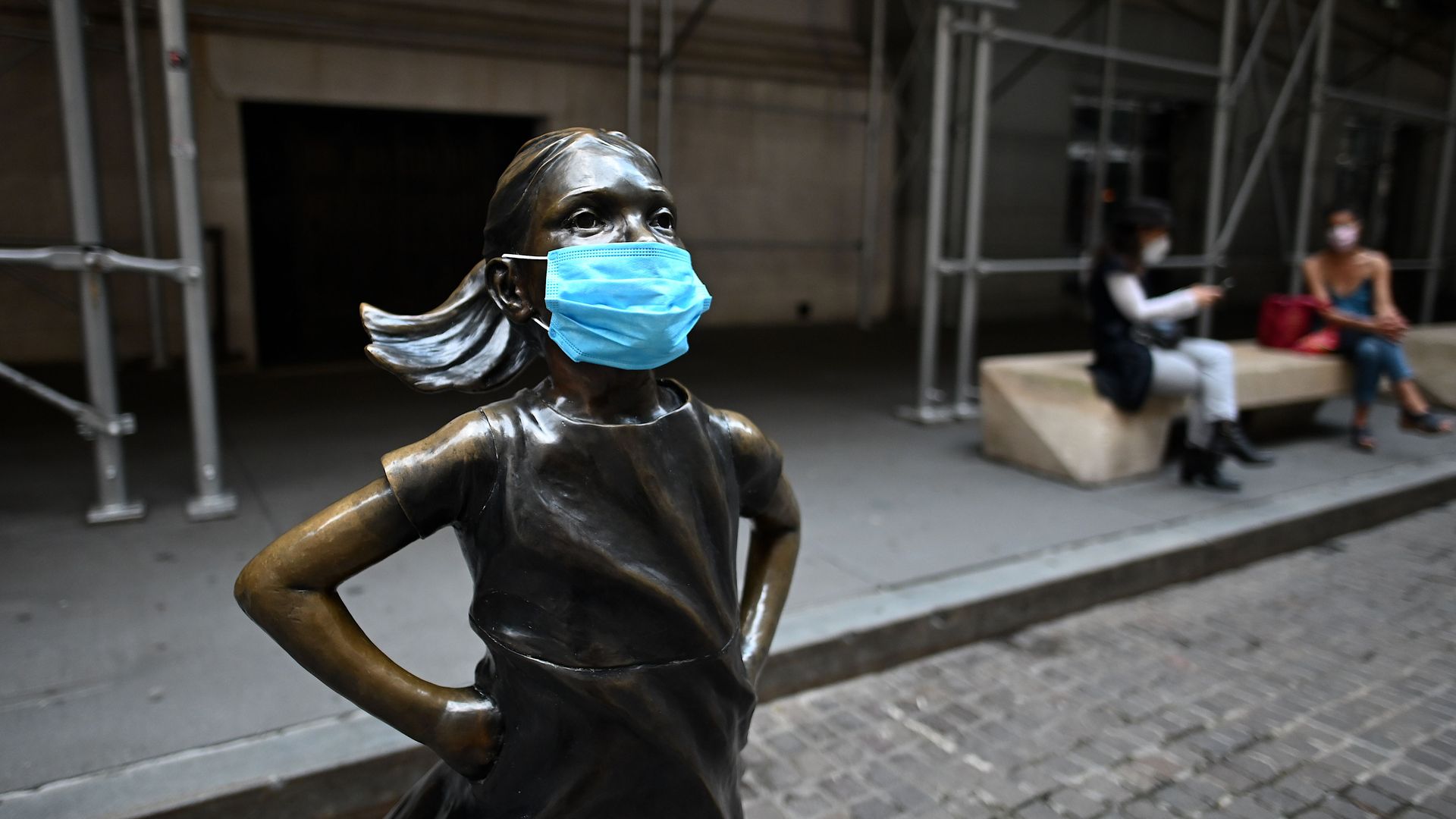Fearless Girl statue with a mask