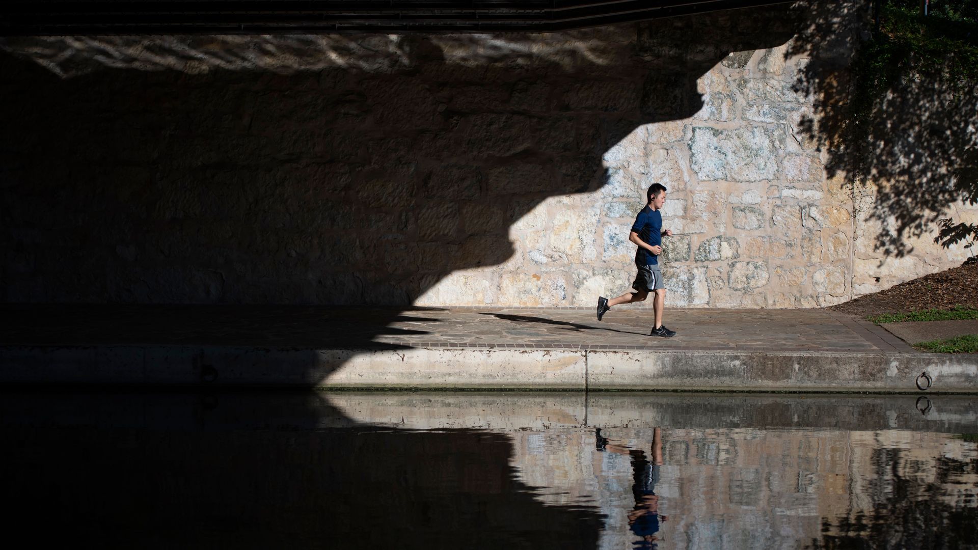 A jogger is seen from across the River Walk in San Antonio
