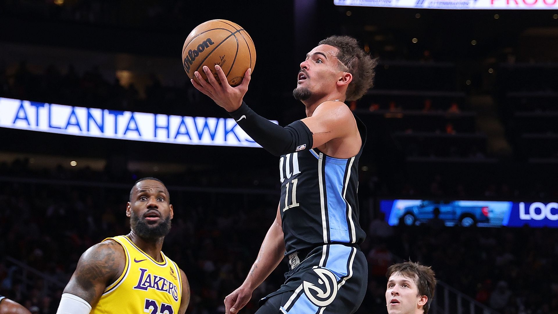 A man in a black uniform shoots a basketball 