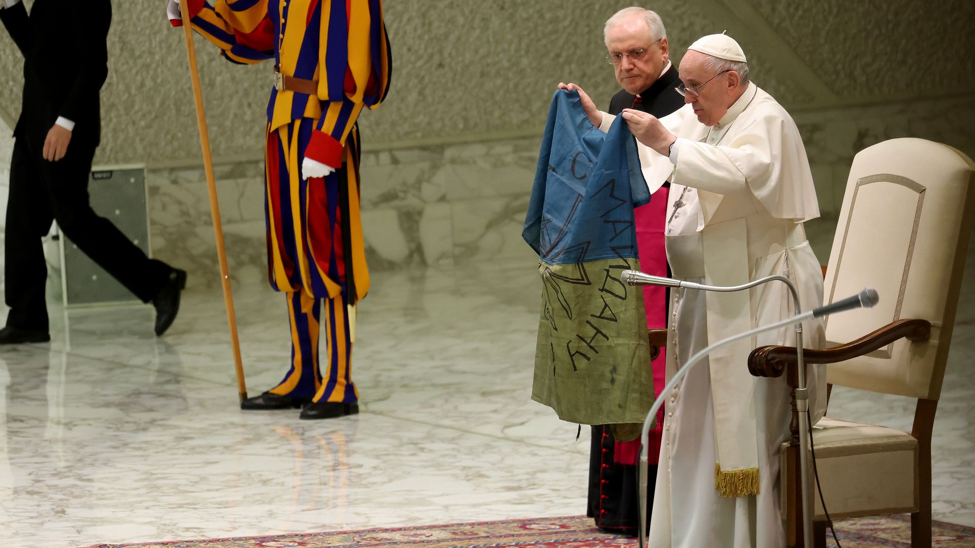 Pope Francis holding a faded Ukrainian flag from Bucha in the Vatican on April 6.