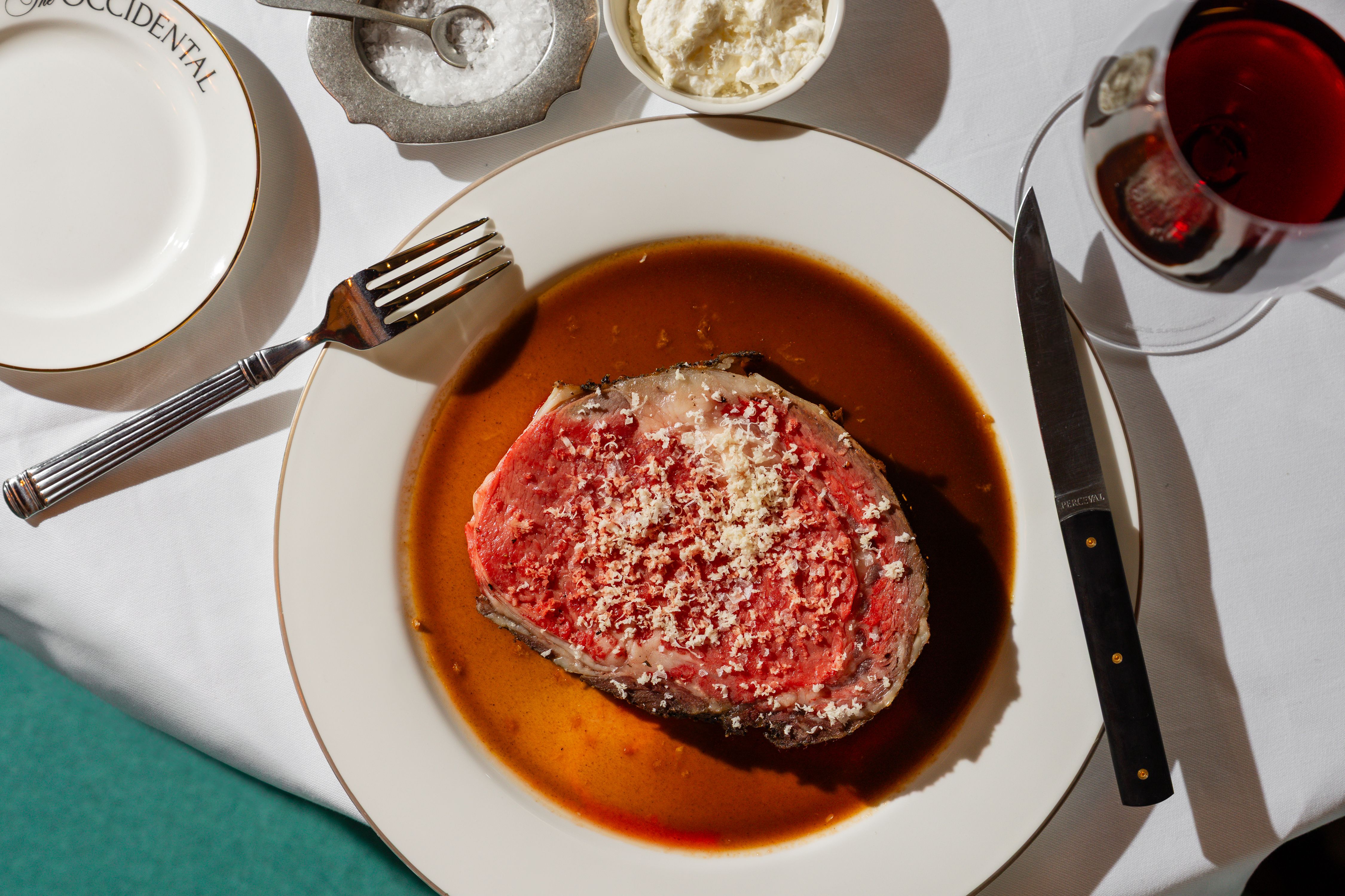 Prime rib au jus on a white table