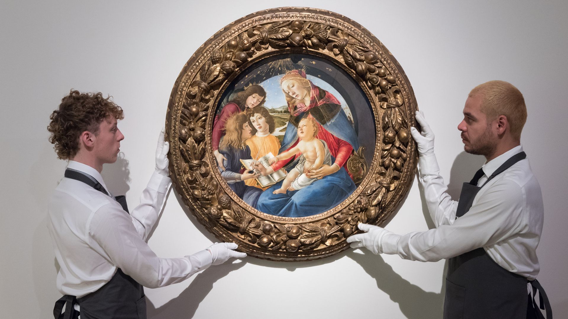 Art handlers hold a painting titled 'Madonna of the Magnificat' by Alessandro Filipepi, called Sandro Botticelli in London, England.