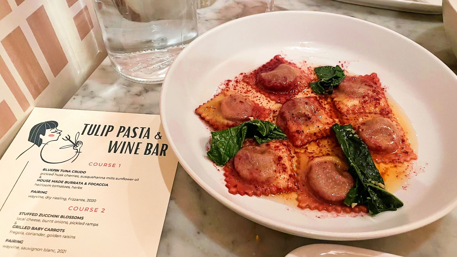 A plate of ravioli next to a menu for Tulip Pasta & Wine Bar in Fishtown.