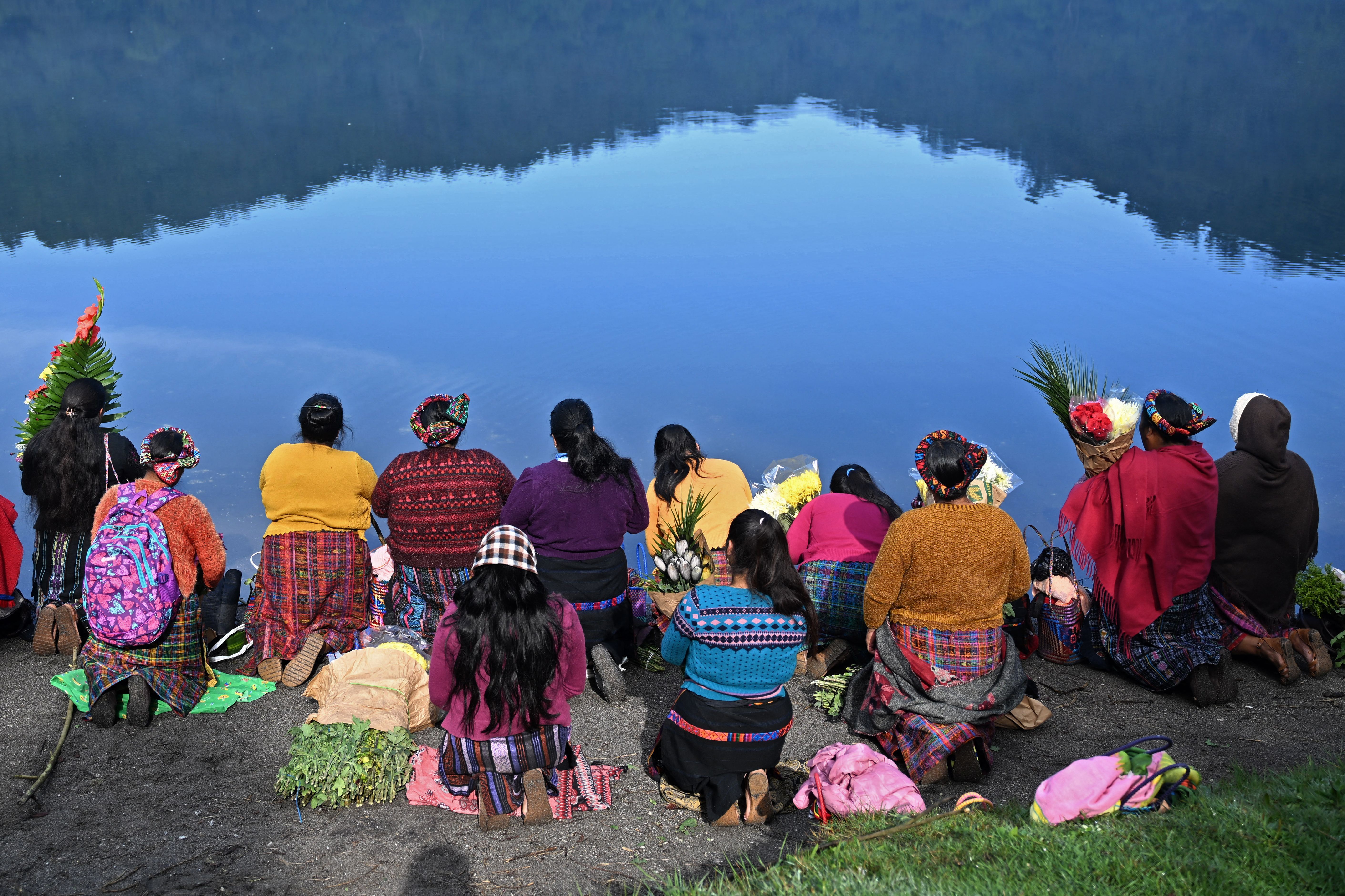 Indigenous women take part in the 'Prayer for Rain' ceremony on the shore of Chicabal Lagoon, formed in the crater of an extinct volcano and considered by Mayan people as a sacred place, in San Martin Sacatepequez, Guatemala, on May 18, 2023.