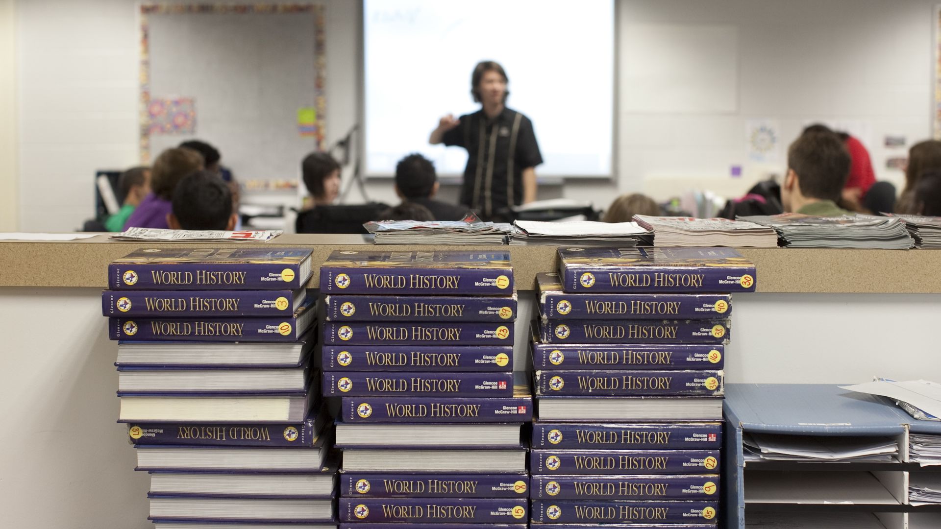 World history textbooks stacked up on a table.
