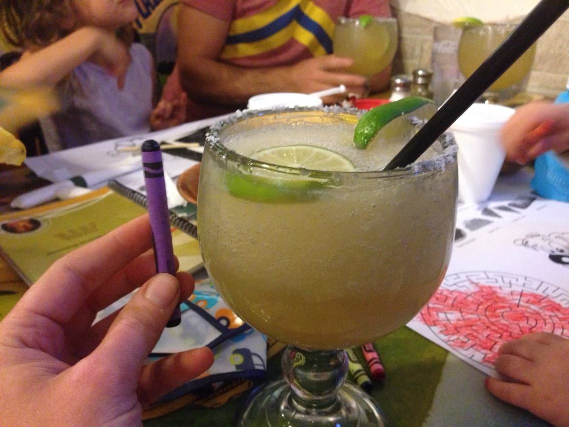 A fishbowl margarita with a crayon held up for scale.