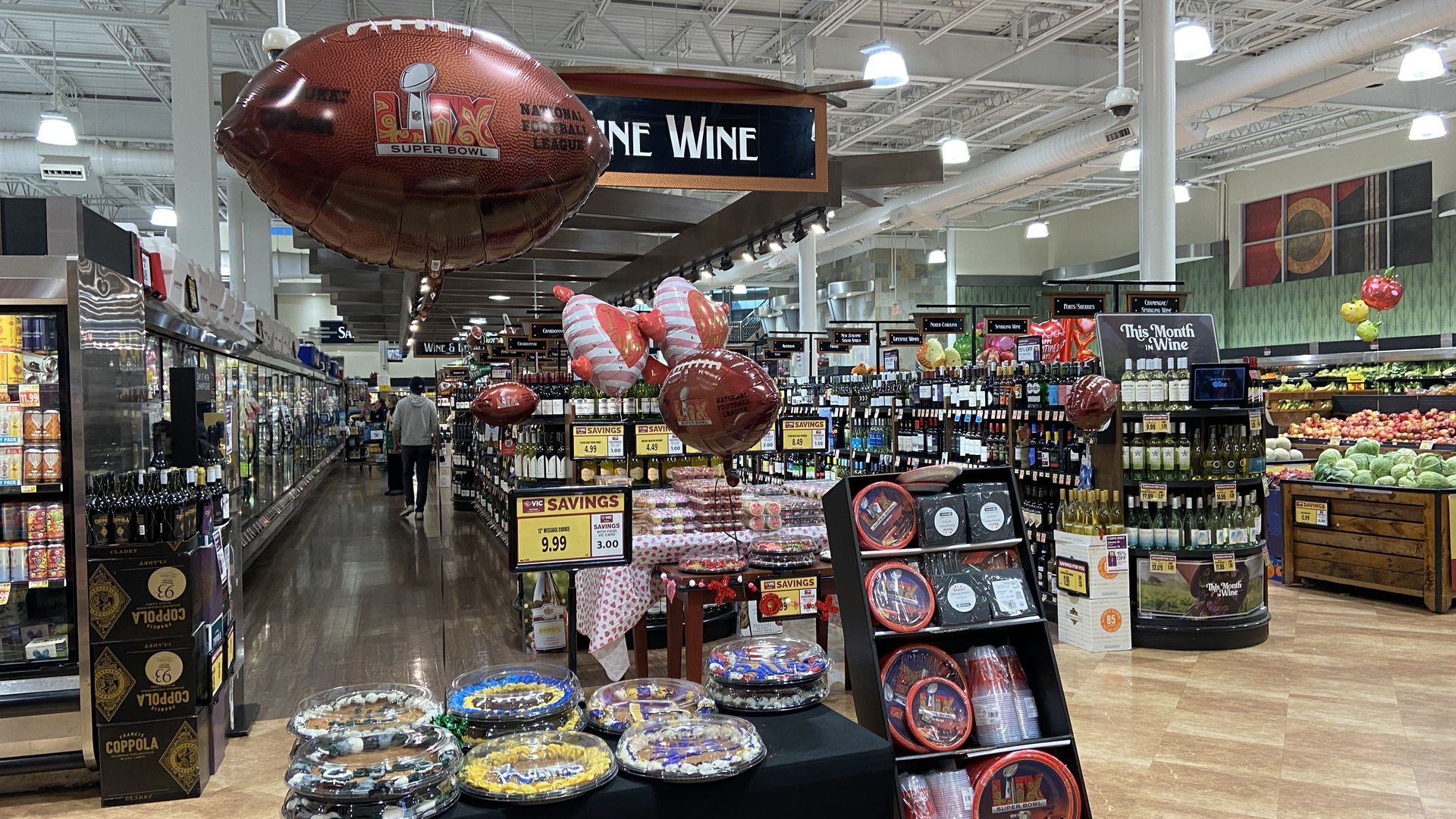 Super Bowl display at a grocery store with balloons shaped like footballs. 