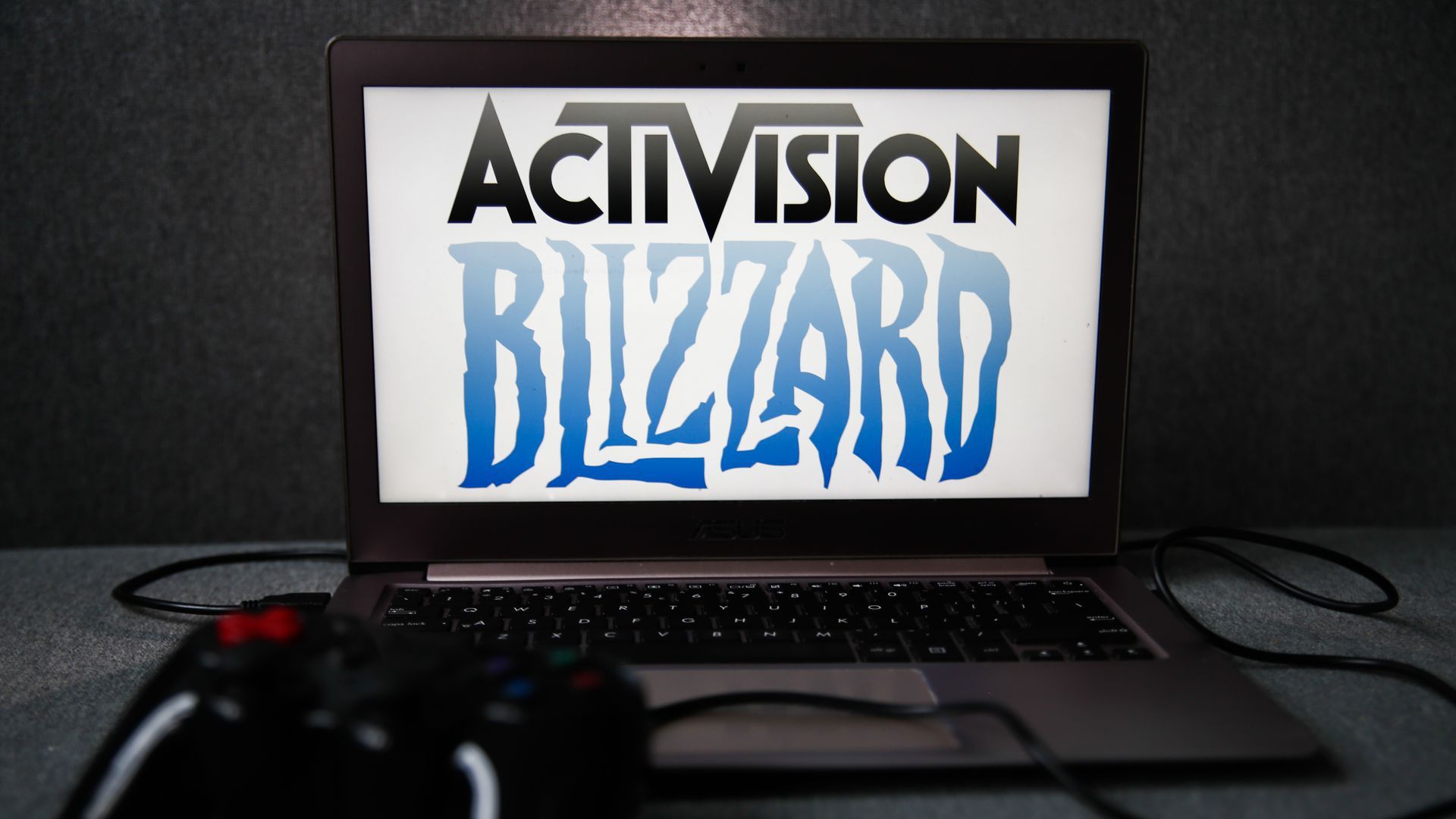 A logo for Activision Blizzard as seen on a laptop screen in front of a dark background.