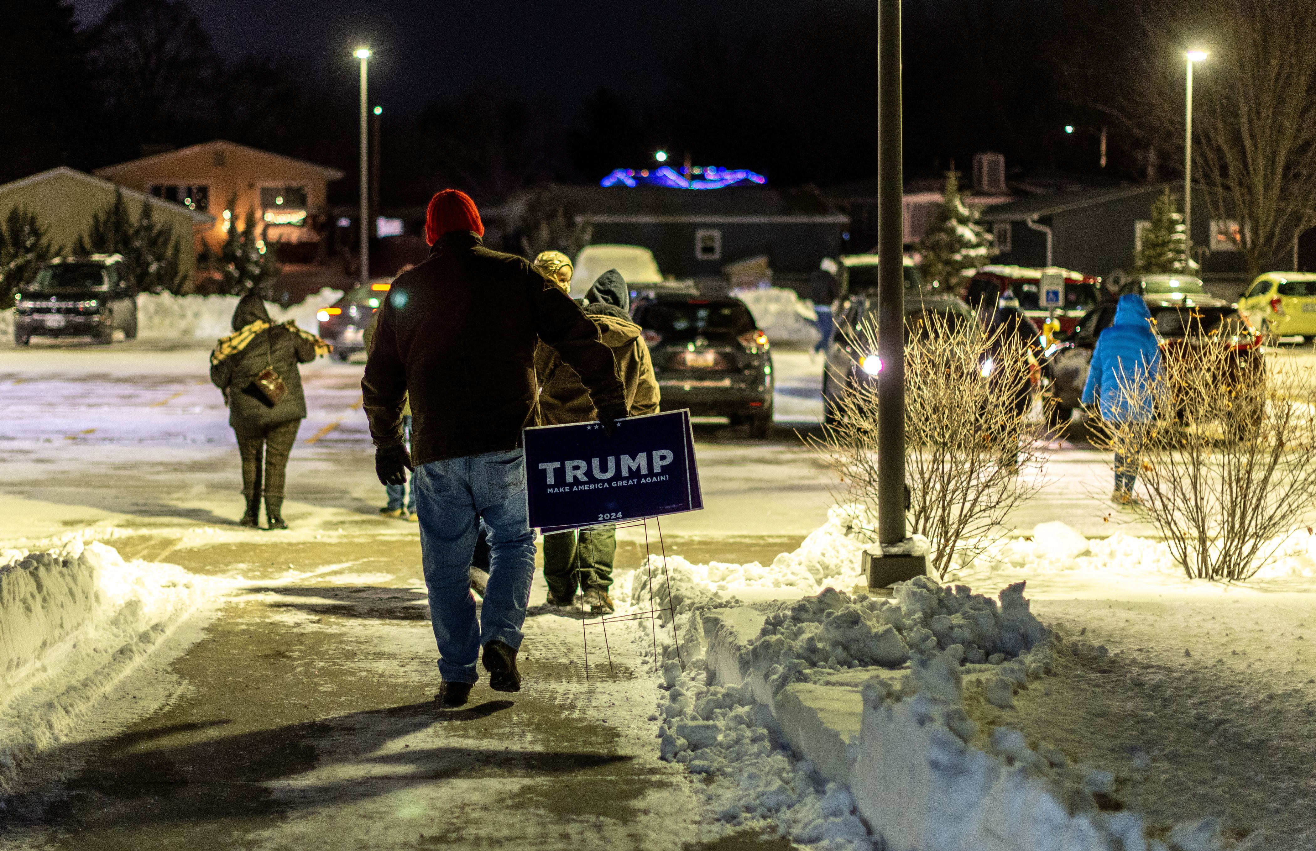 A caucus goer leaves with a Trump sign after Trump won the Iowa Caucuses in this precinct by nine votes at Mitchell Elementary January 15, 2024 in Ames, Iowa.