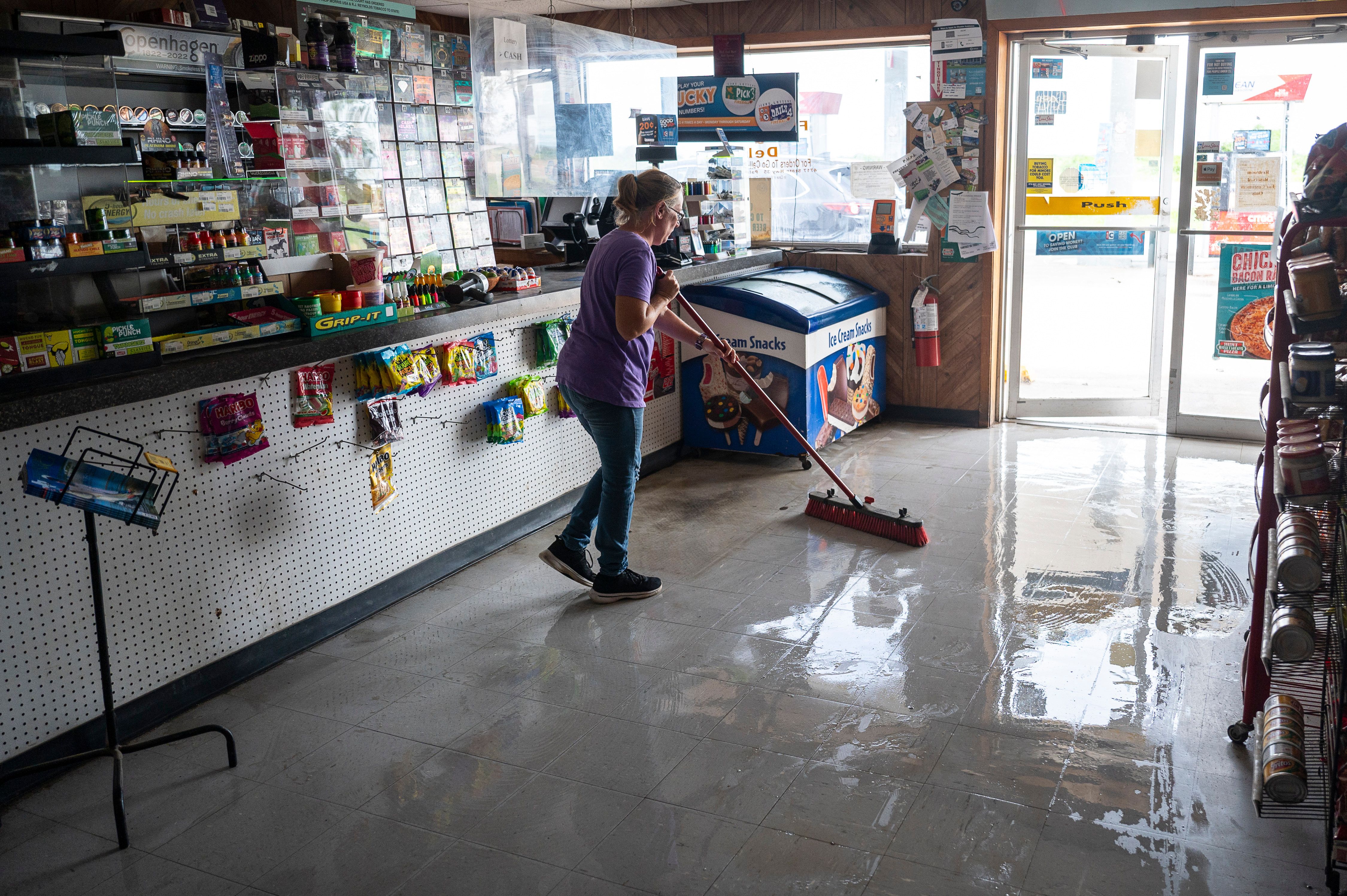A worker sweeps water from a damaged convenience store after Hurricane Beryl made landfall in Palacios, Texas, US, on Monday, July 8