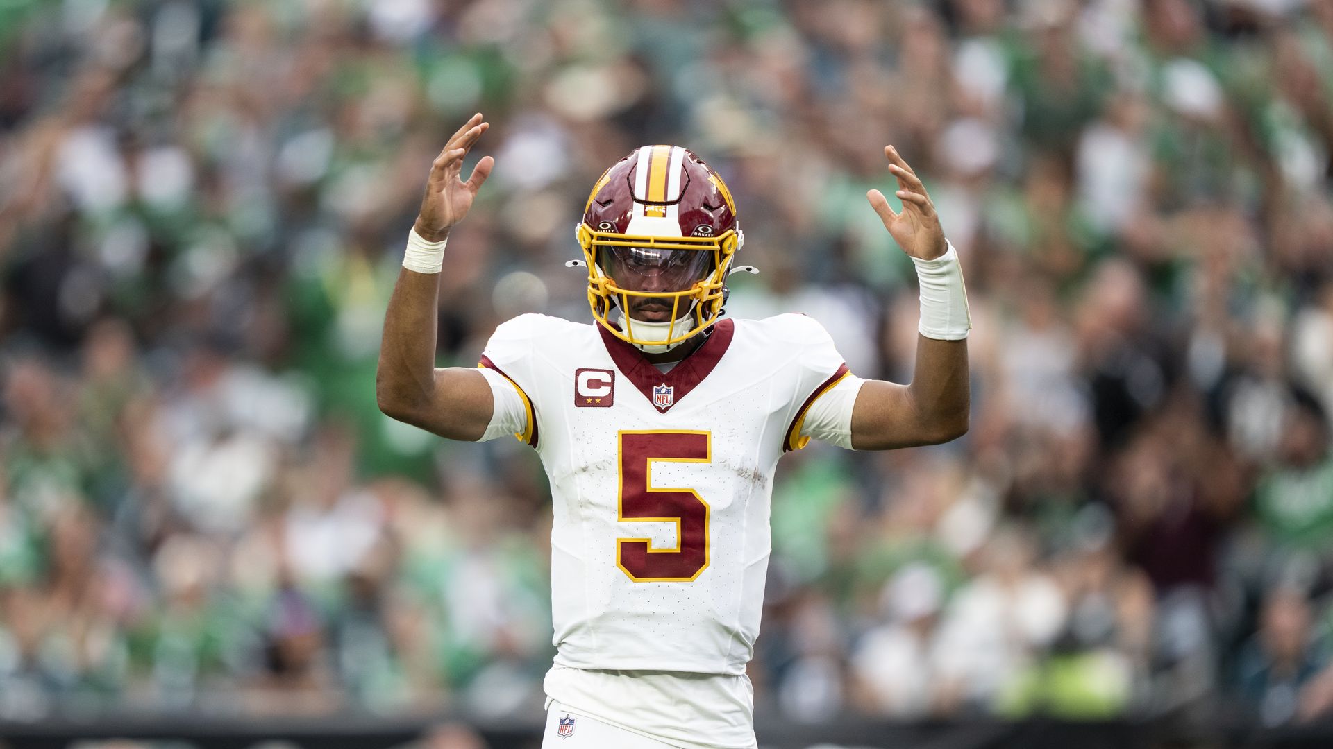 Jayden Daniels throws his hands up in the air, while looking off to the side.